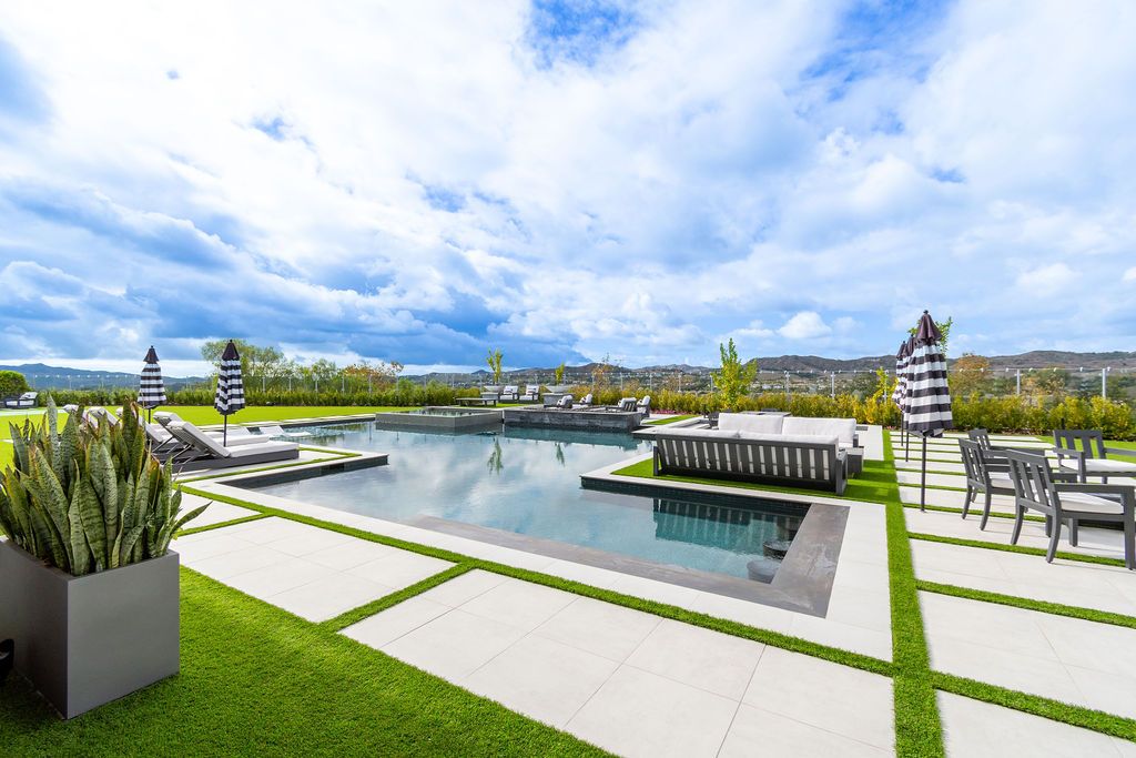 There is a large swimming pool in the middle of the backyard.