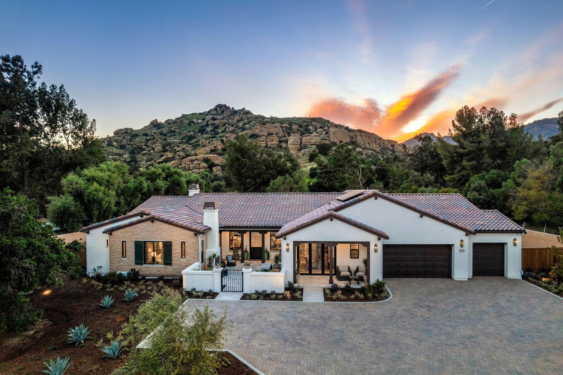 A large white house with a sunset in the background
