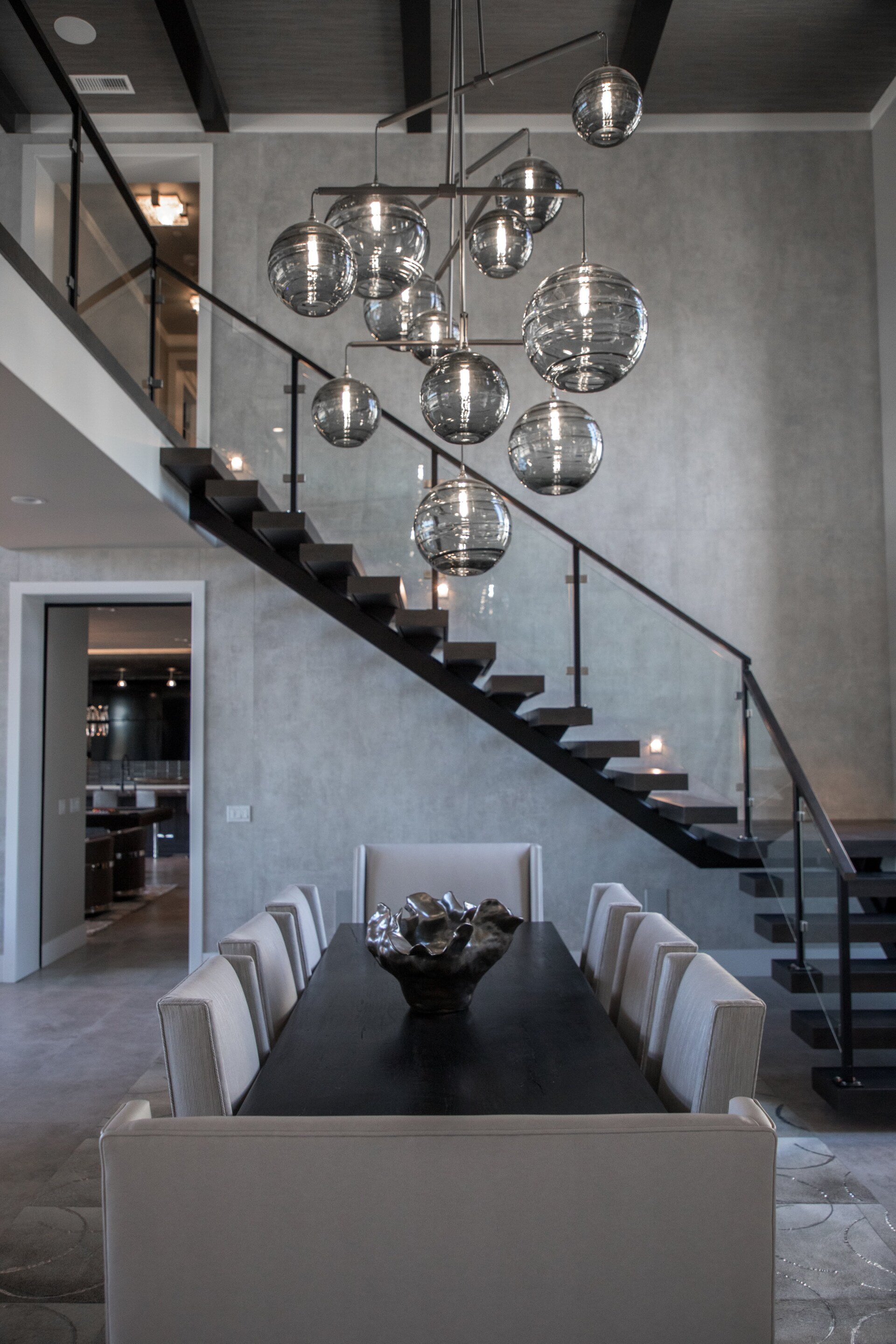 A dining room with a staircase and a table and chairs