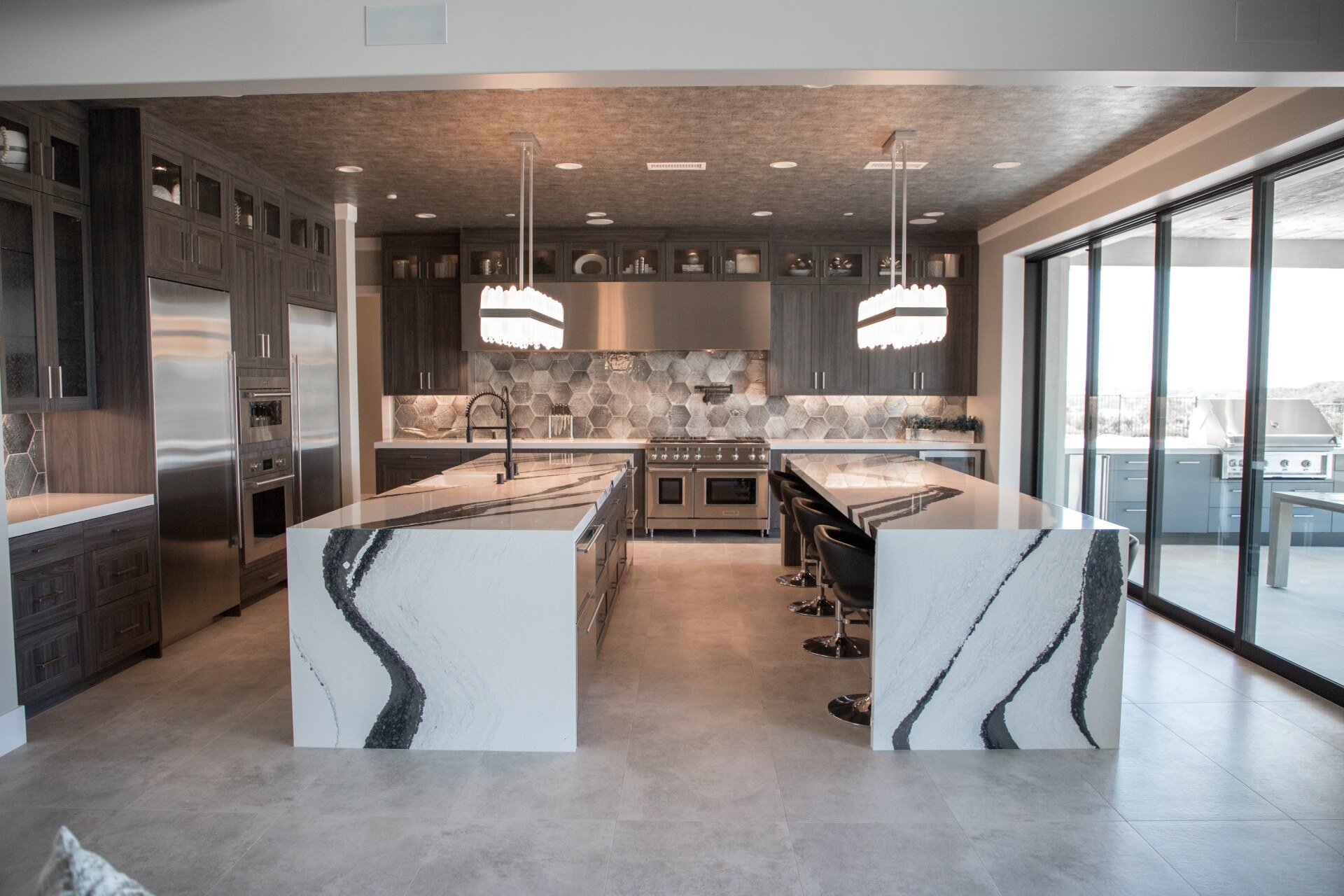 A large kitchen with two islands and stainless steel appliances.