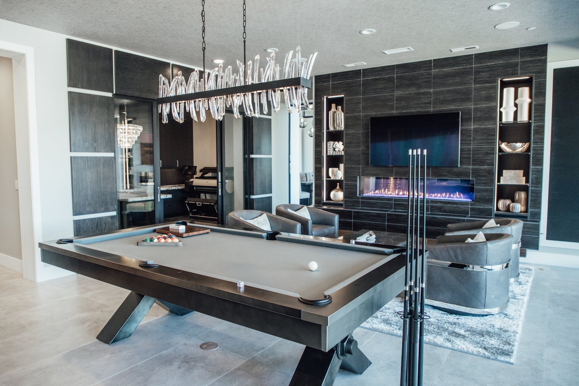 A pool table is in the middle of a living room.