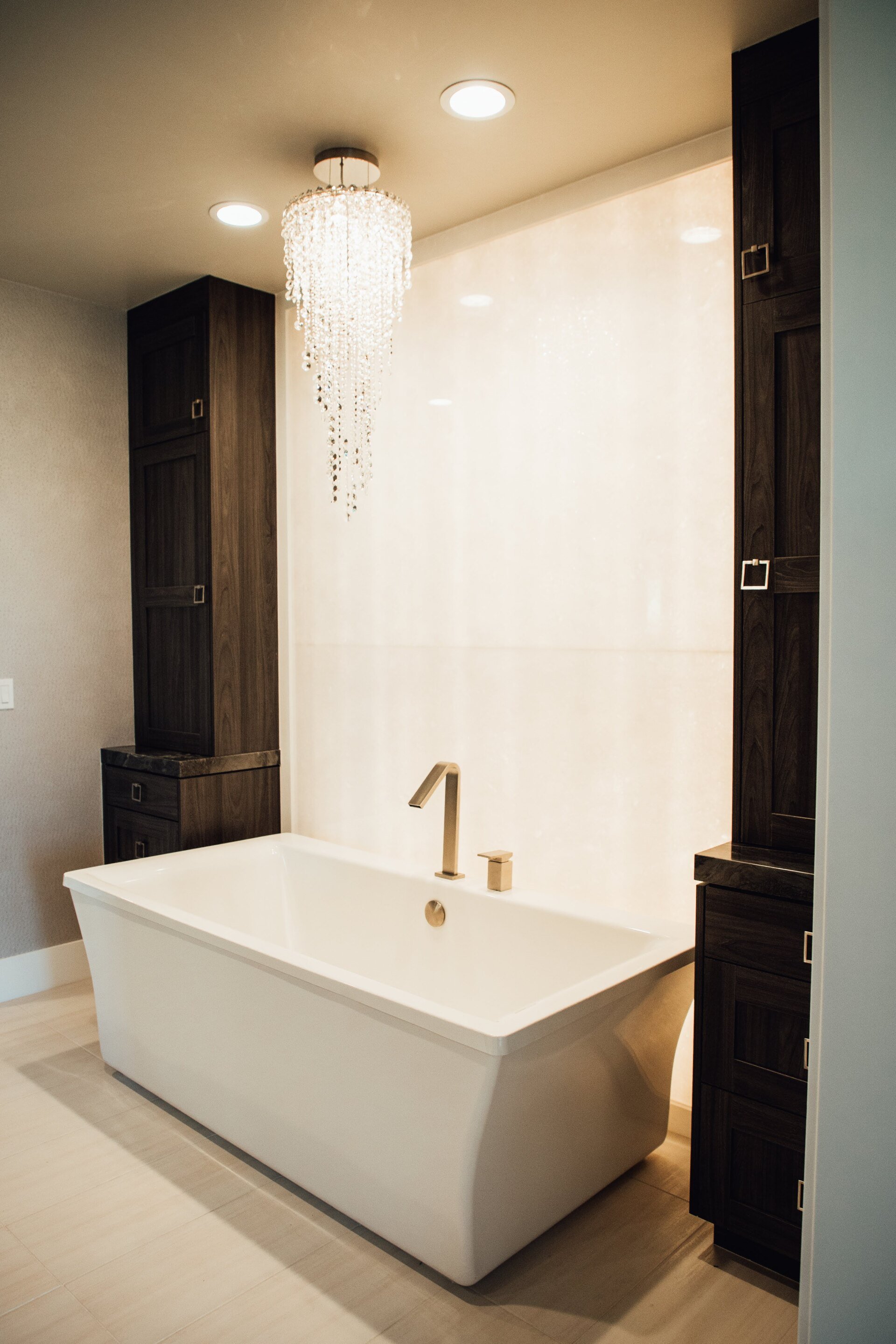 A bathroom with a bathtub and a chandelier hanging from the ceiling.