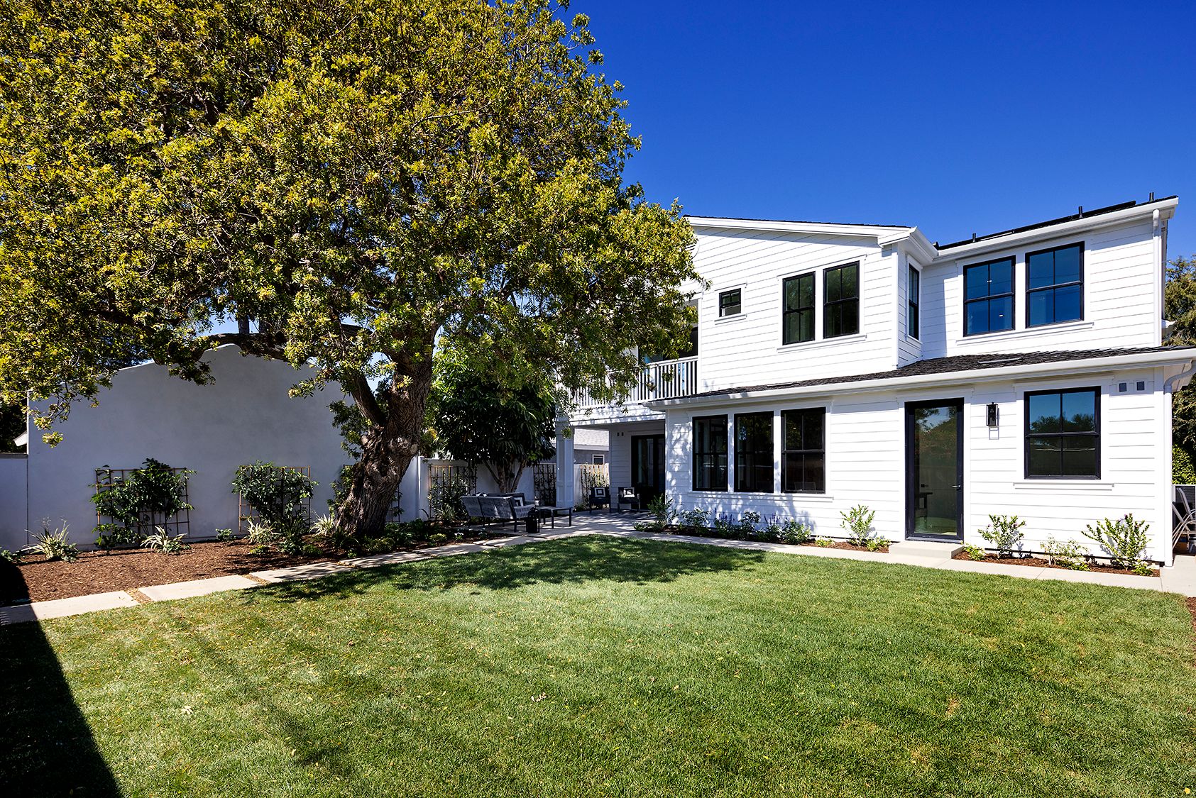 A large white house with a large lawn in front of it.