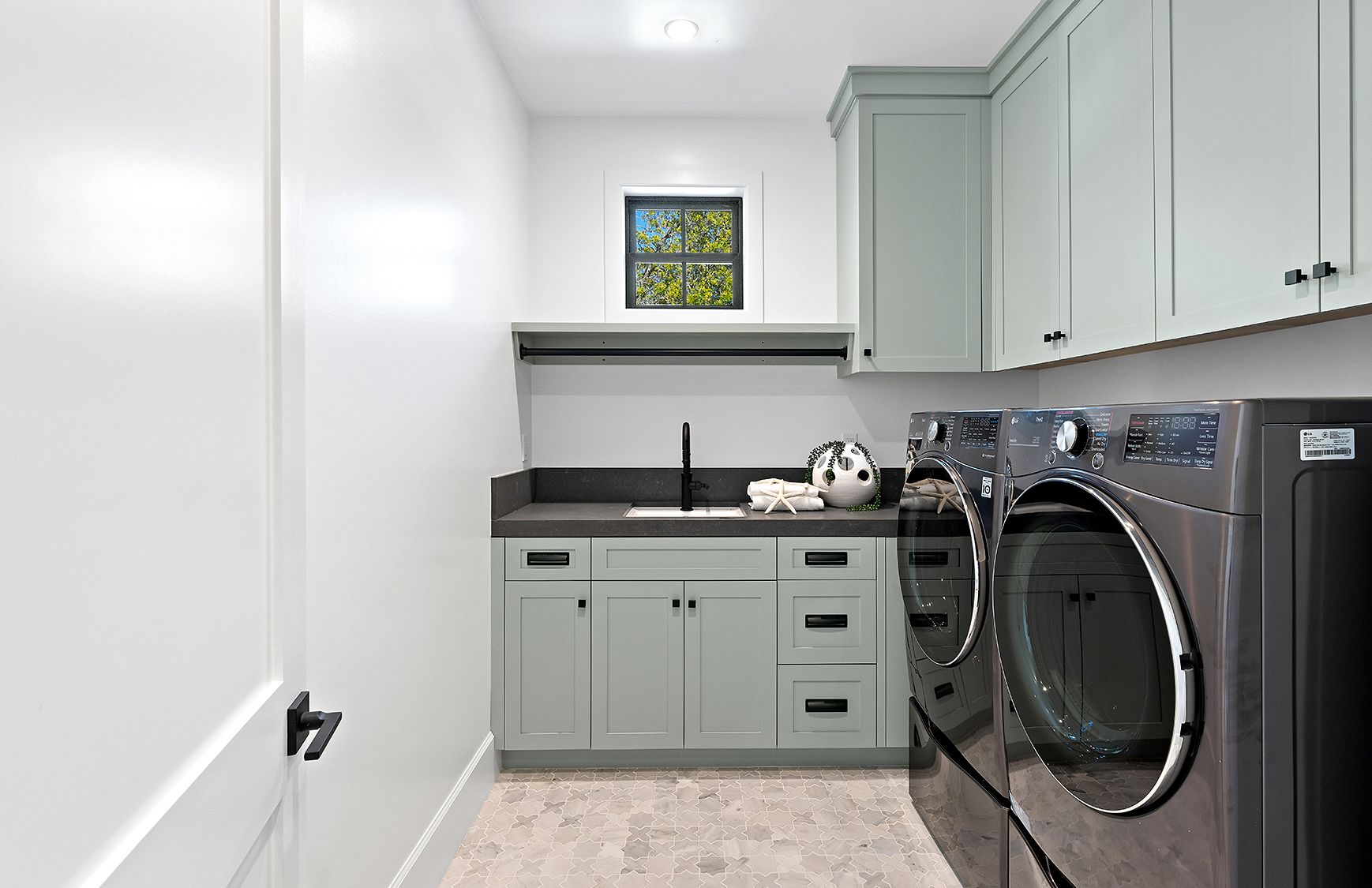 A laundry room with a washer and dryer and a sink.