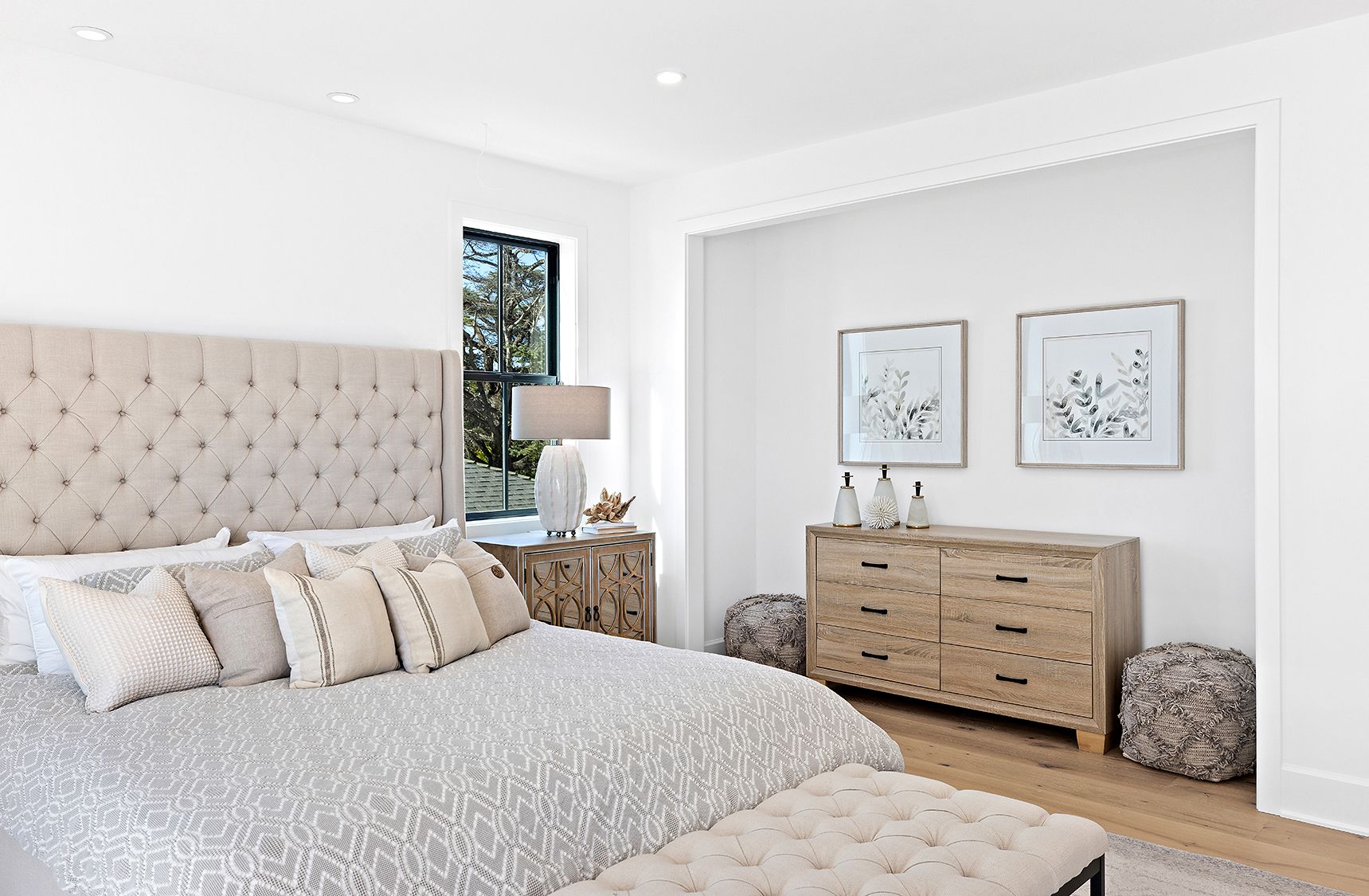A bedroom with a bed , dresser , and bench.