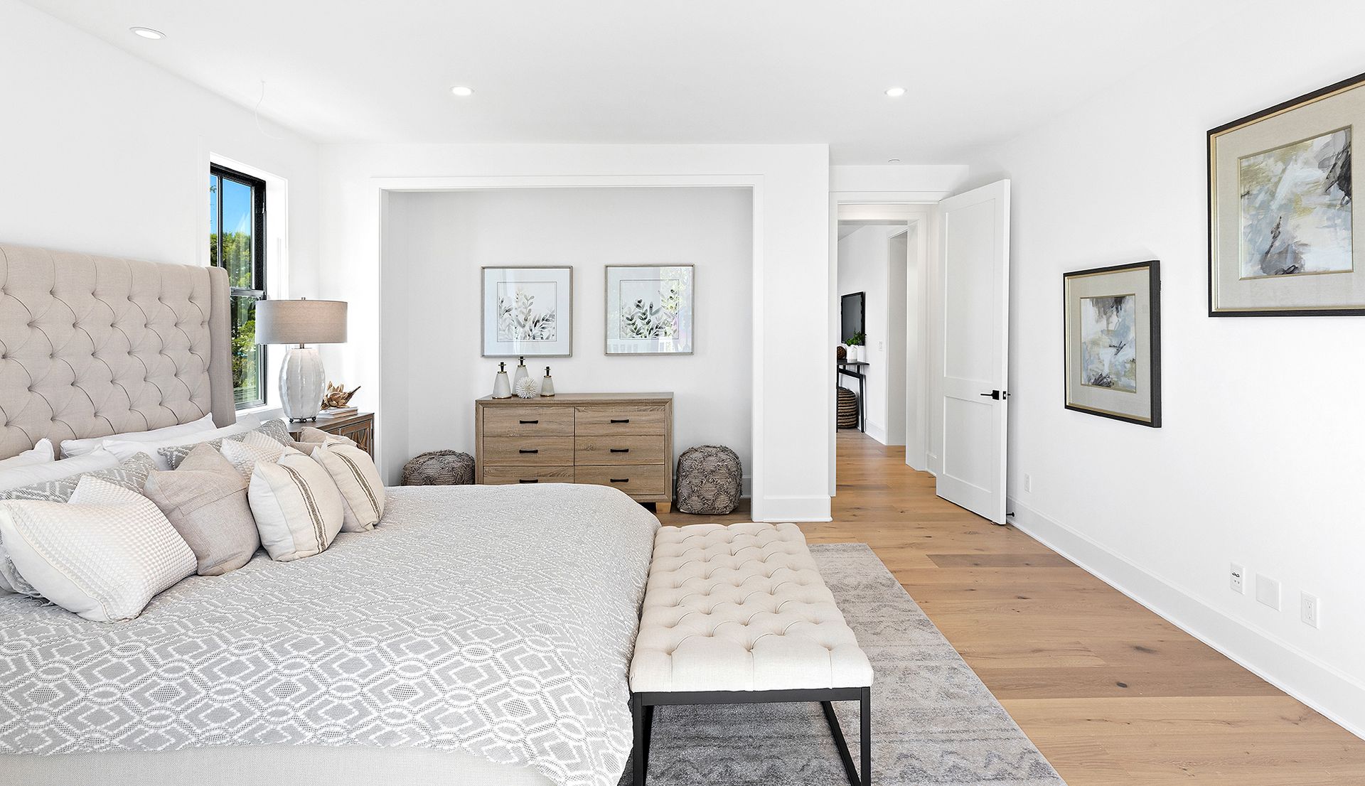 A bedroom with a large bed , dresser and bench.