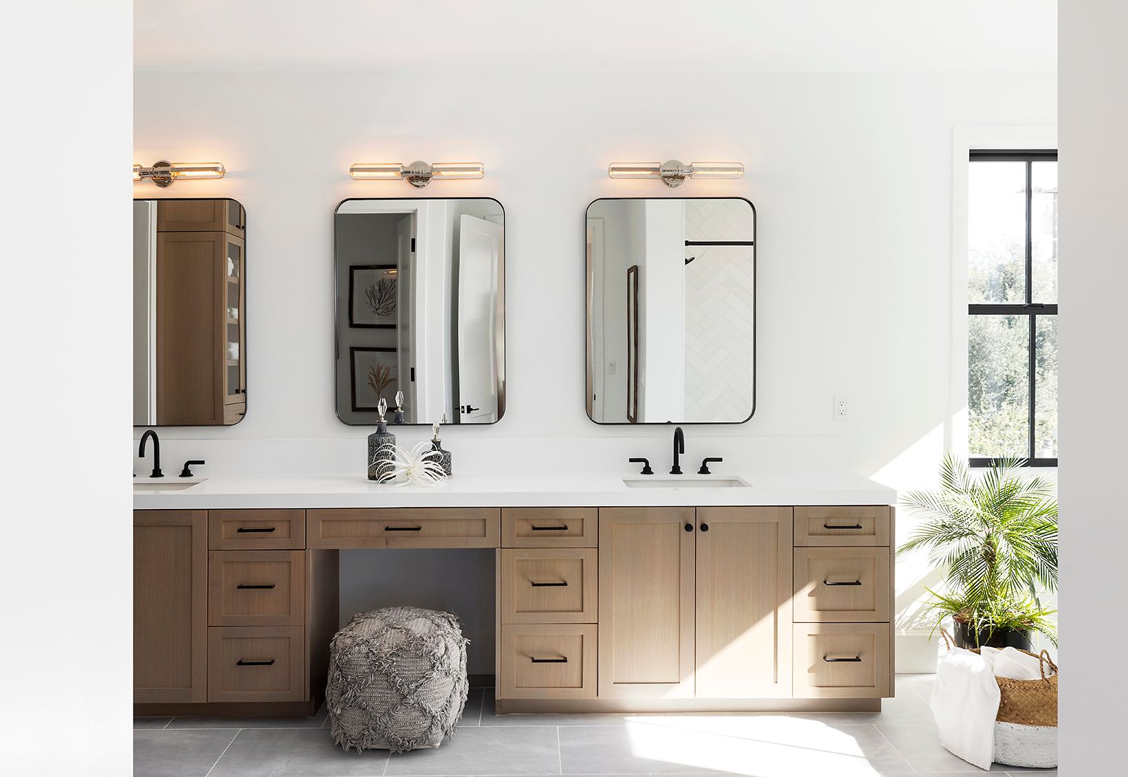 A bathroom with two sinks and three mirrors.