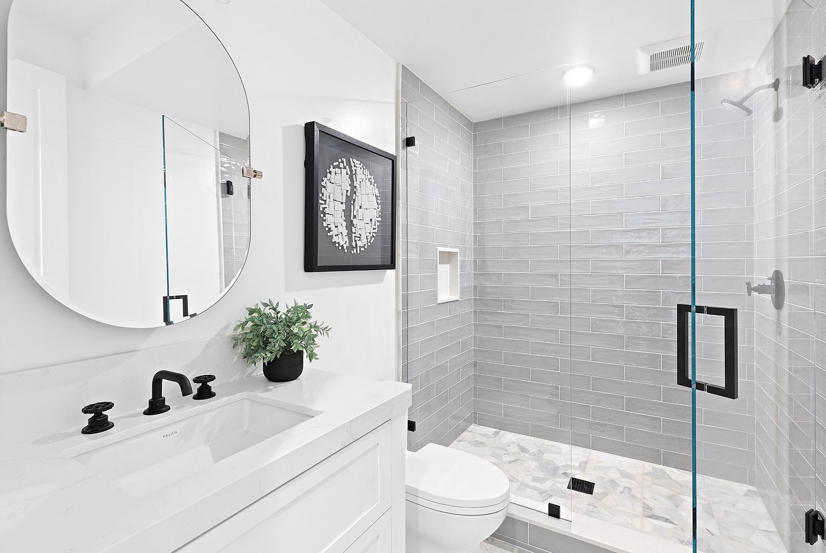 A bathroom with a sink , toilet , shower and mirror.