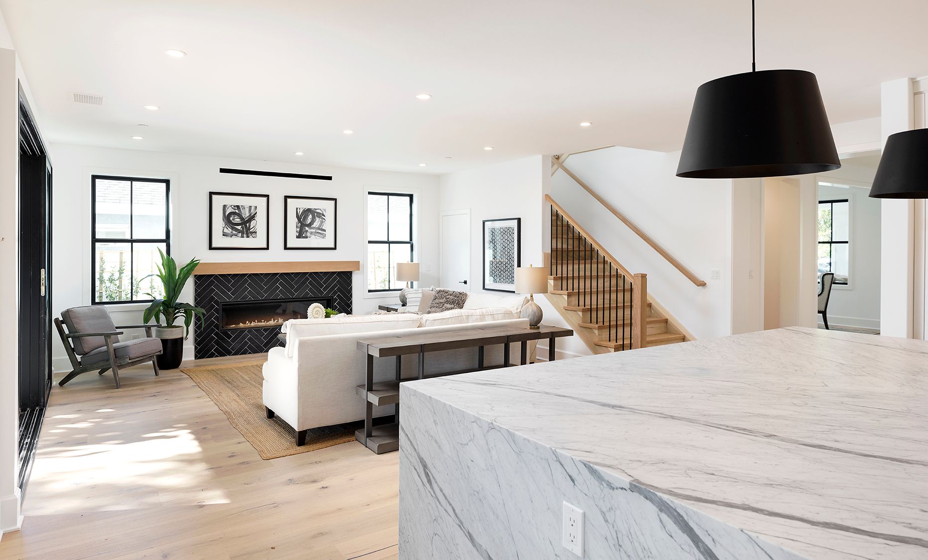 A living room with a fireplace , couch , chair and stairs.
