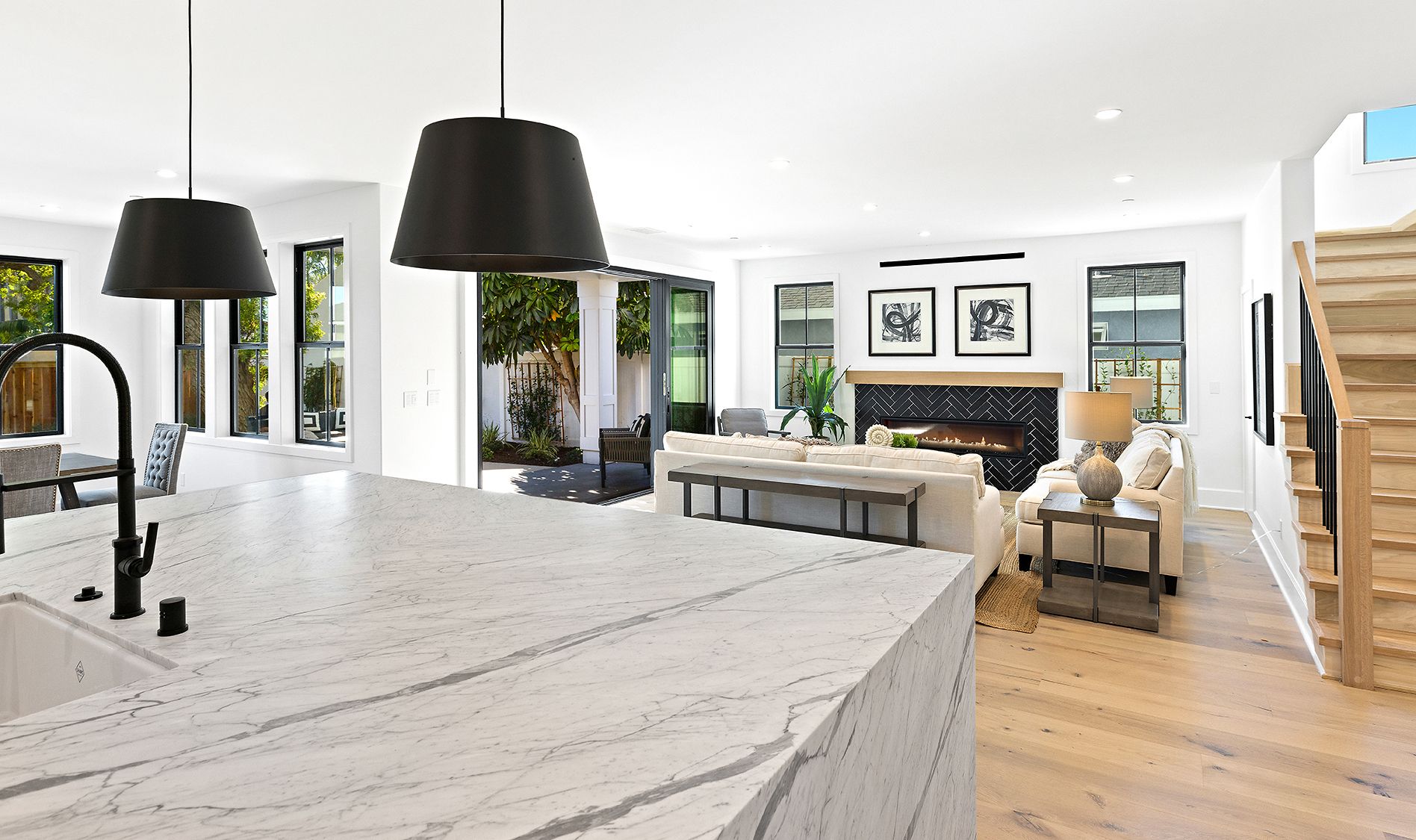 A kitchen with a large island and a living room with a fireplace.