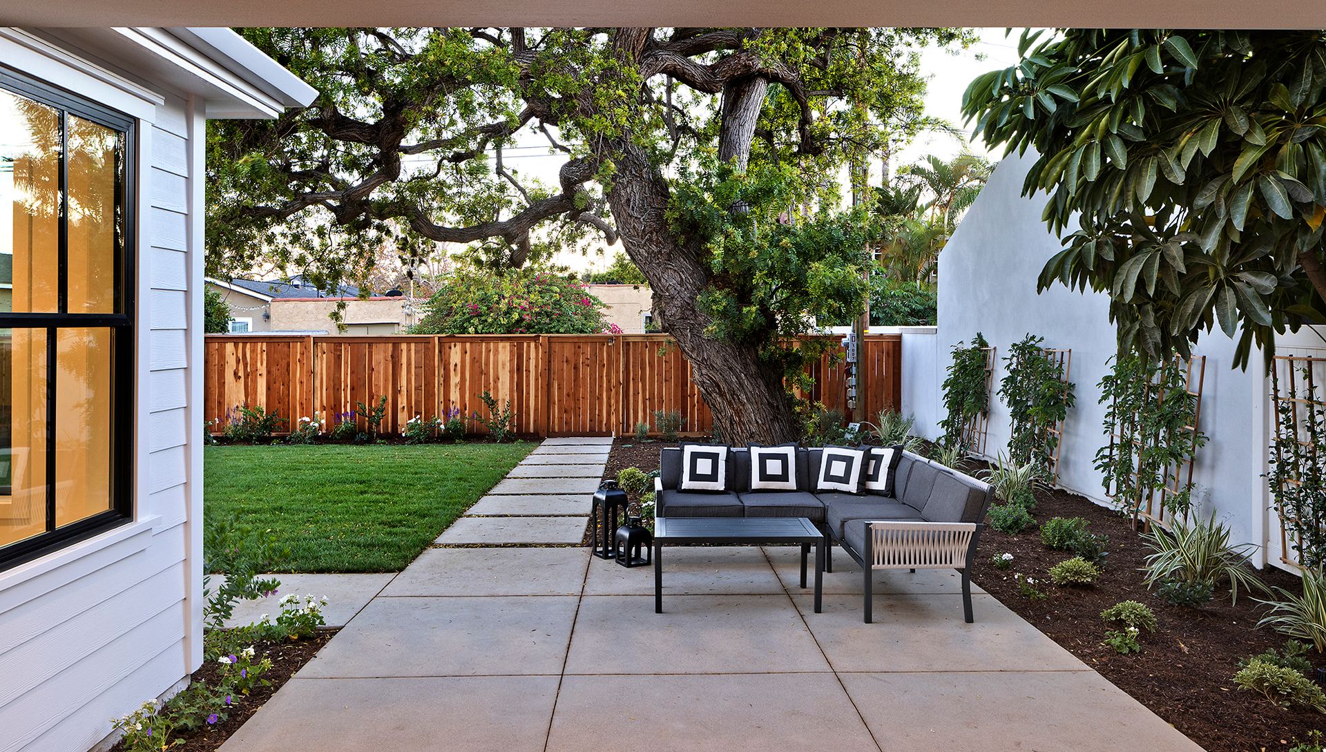 A patio with a couch and a table in the backyard of a house