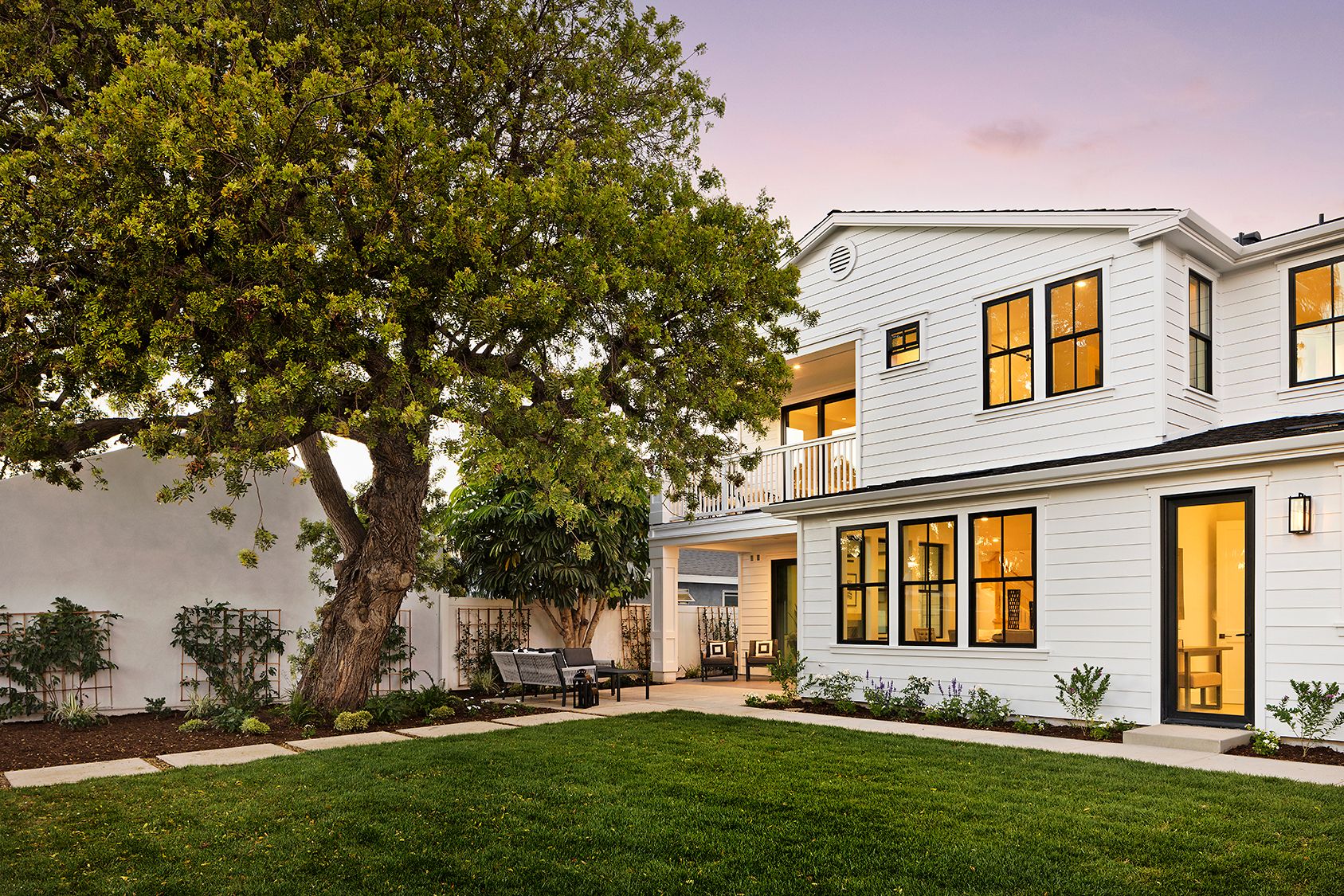 A large white house with a large lawn in front of it.
