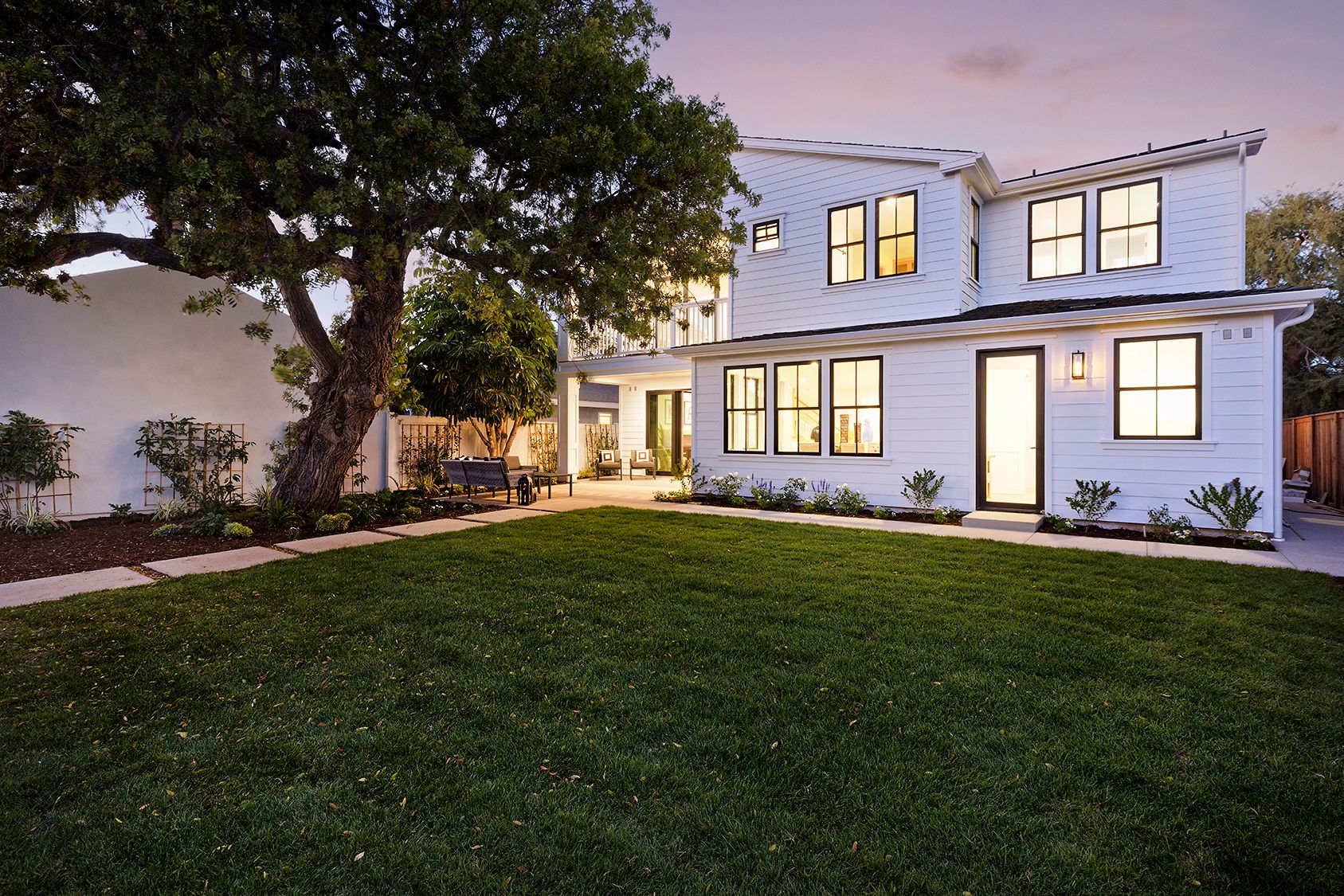 A large white house with a large lawn in front of it.
