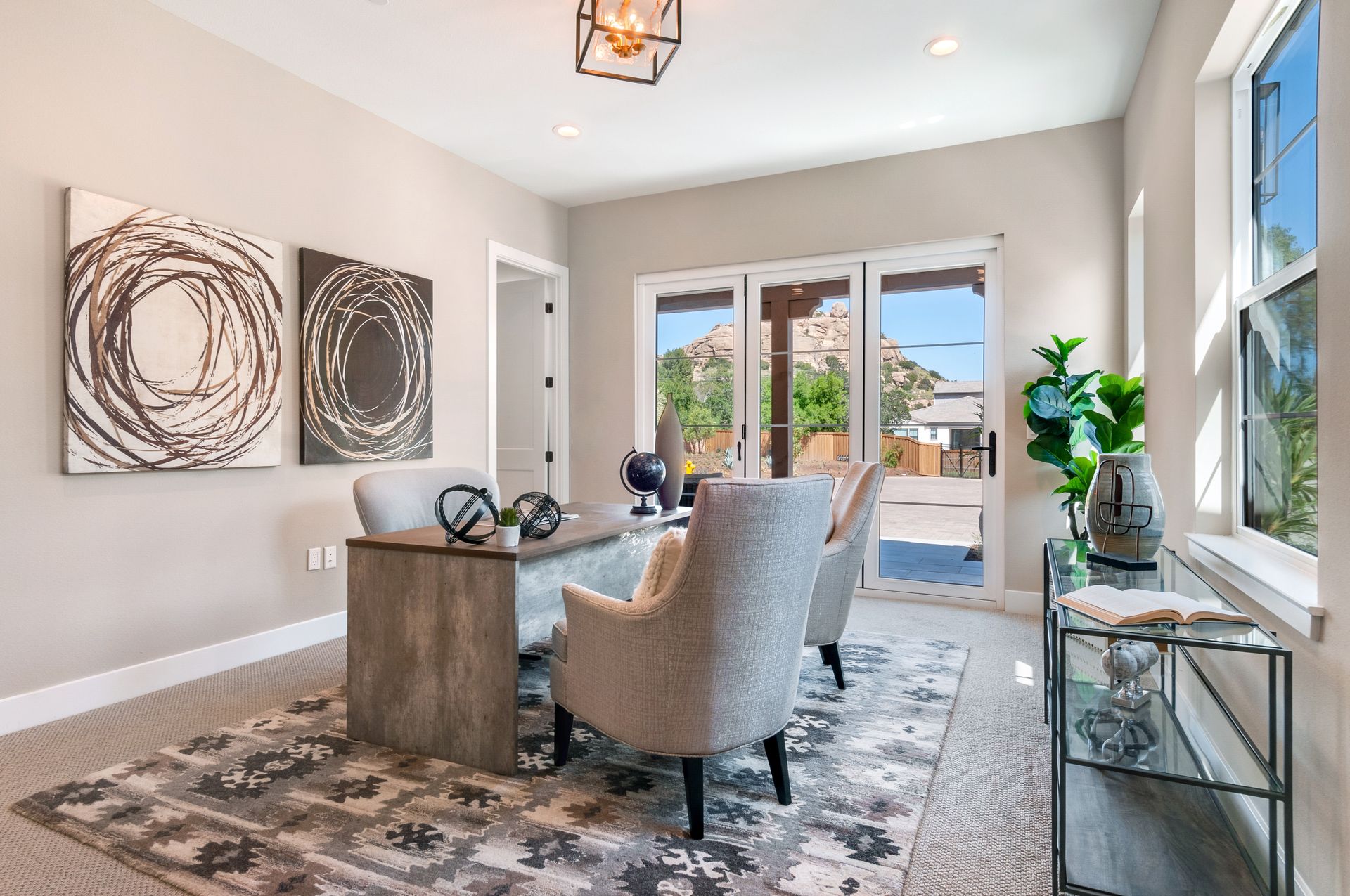 A home office with a desk , chairs , and a rug.