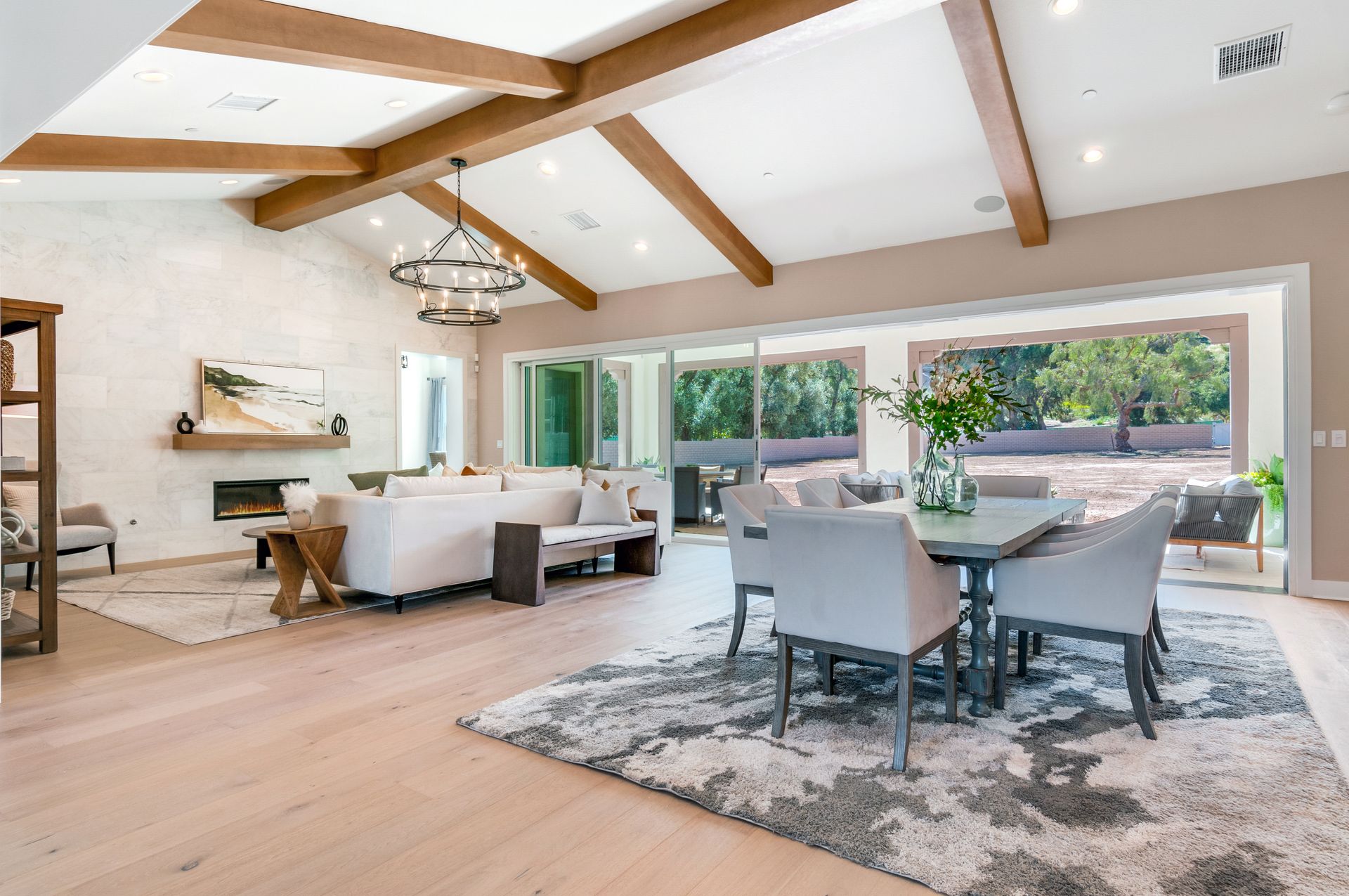 A living room with a dining table and chairs and a fireplace.