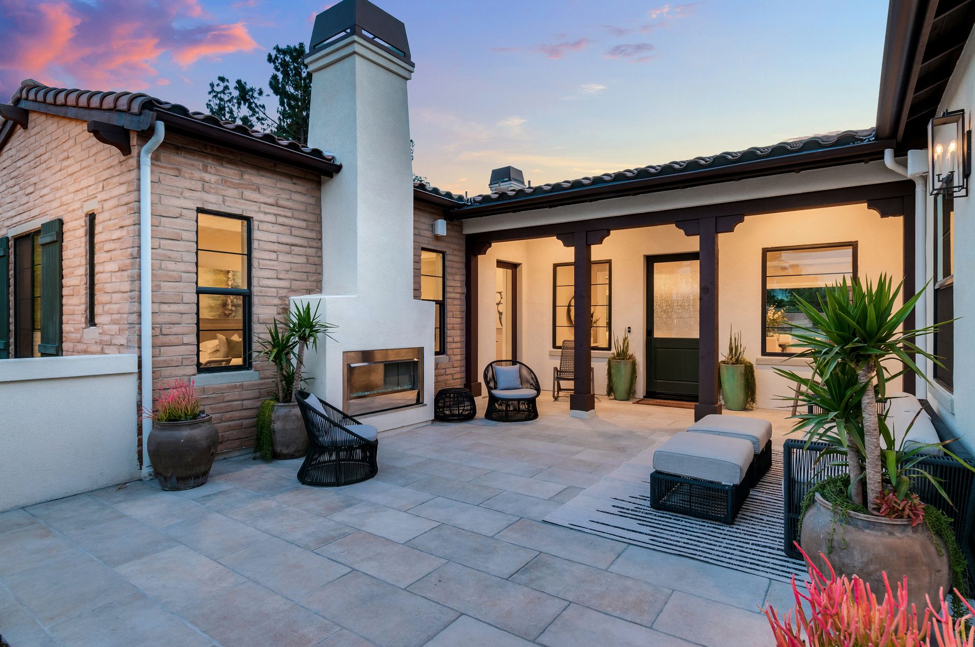 A large brick house with a patio and a fireplace