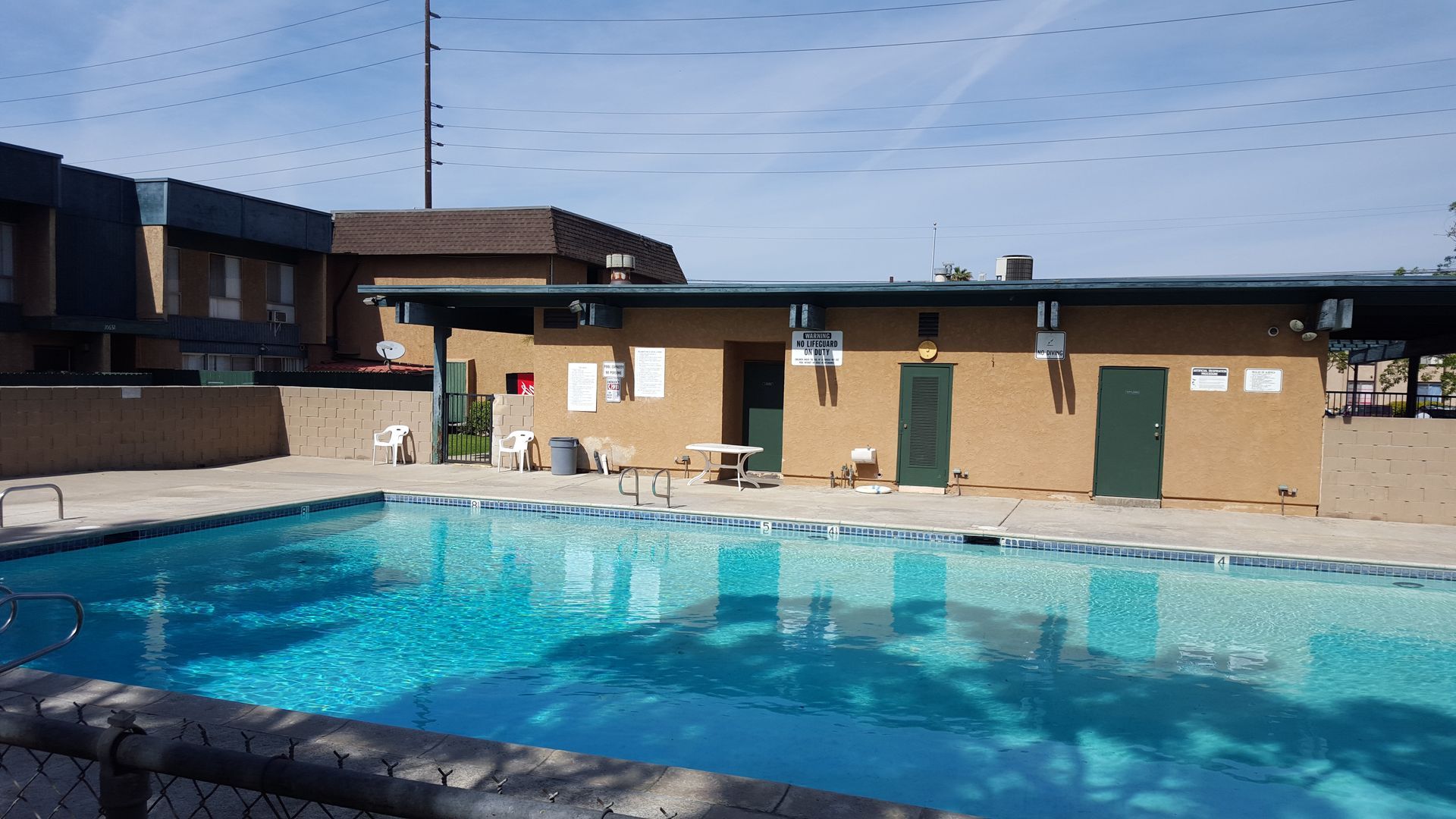 There is a large swimming pool in front of a building.
