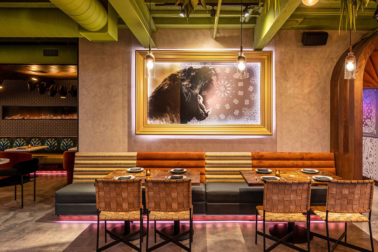 A restaurant with tables and chairs and a painting on the wall.