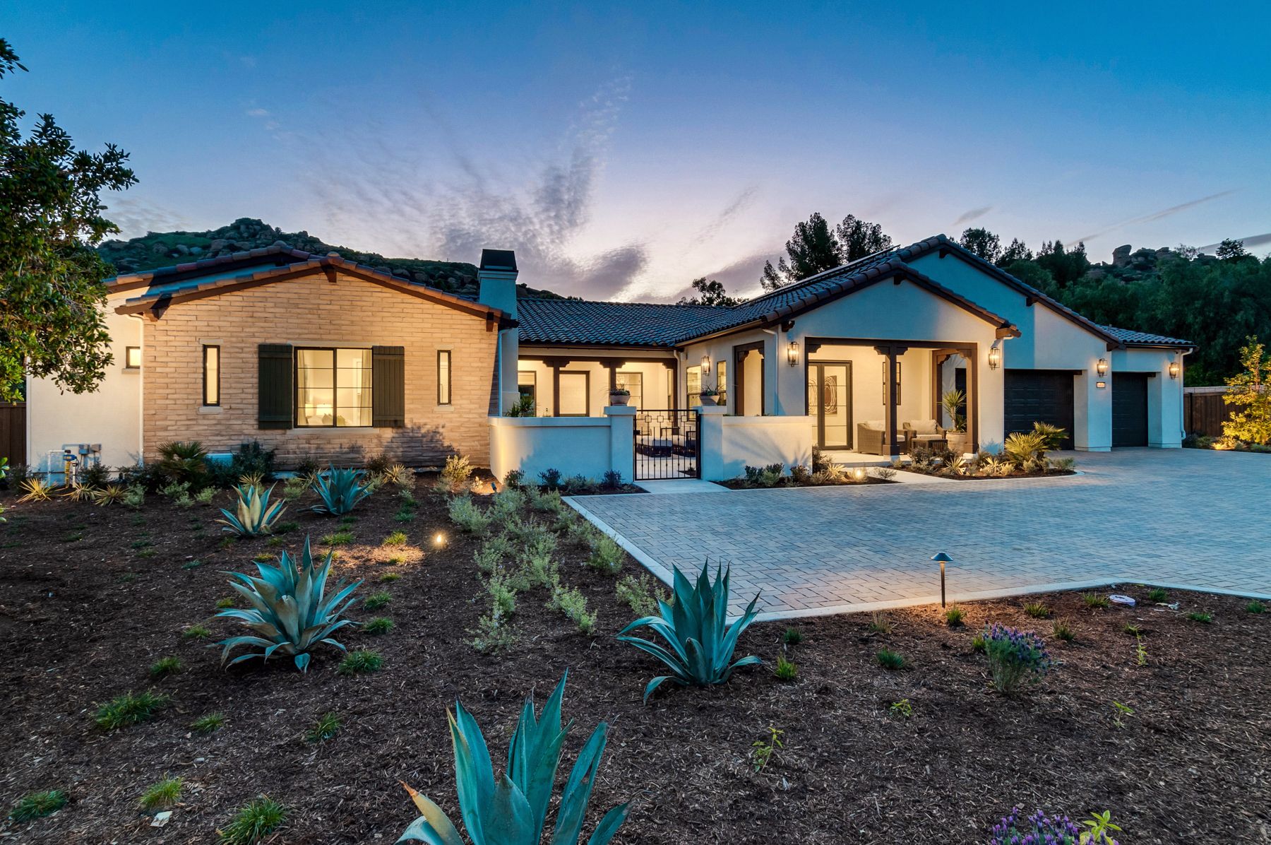A large house with a lot of windows and a lot of plants in front of it.