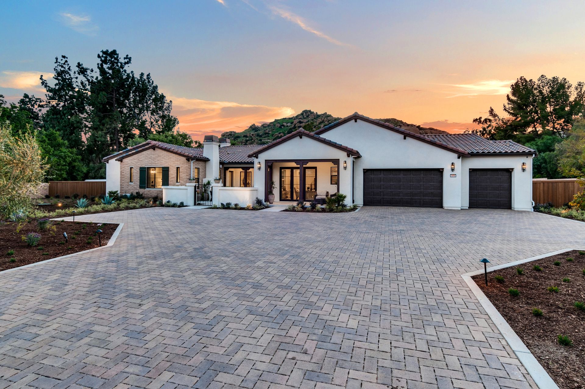 A large house with a brick driveway in front of it
