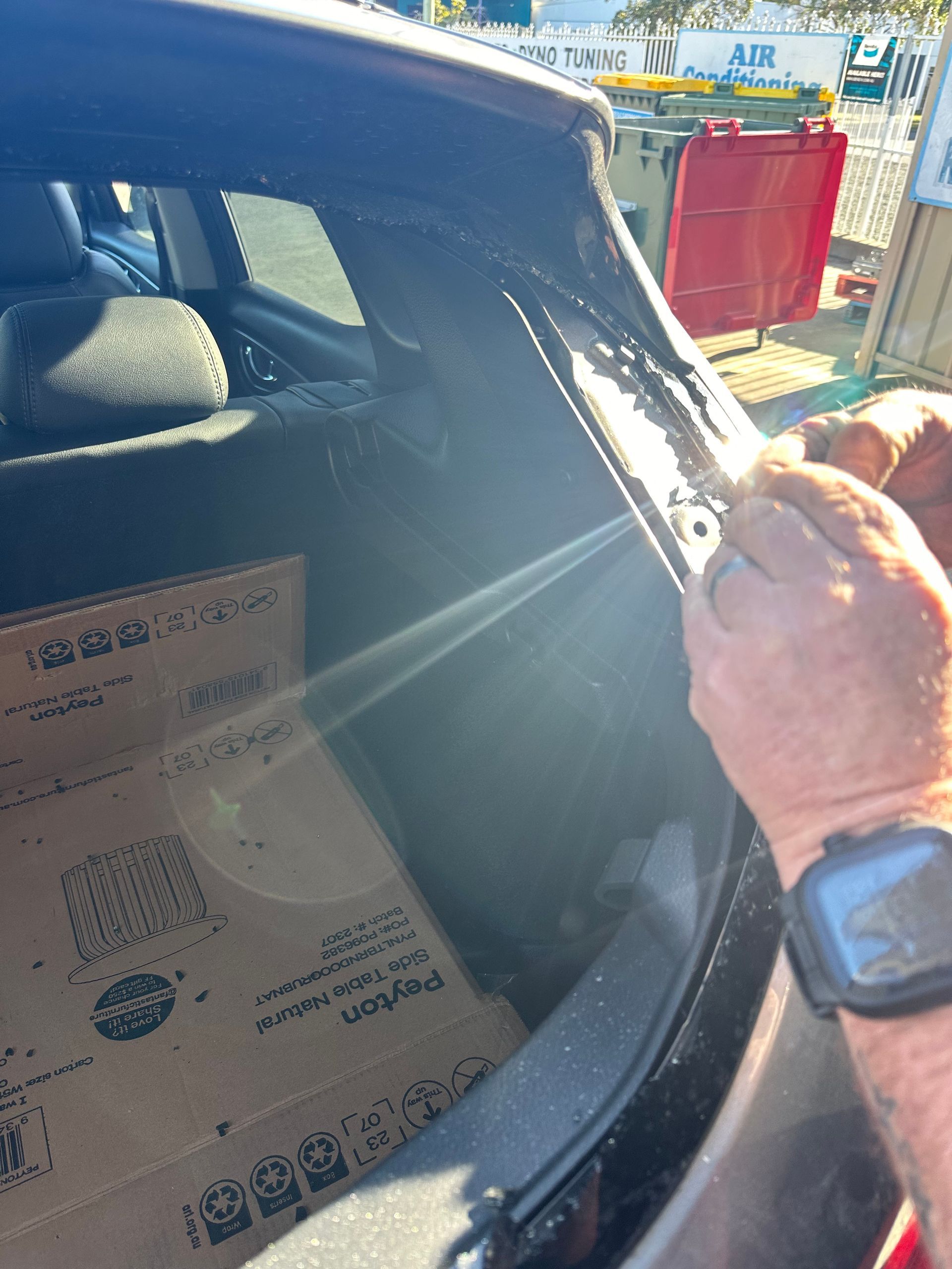 Person Holding a Car Window Frame Near a Windshield — Autopro Taree in Wingham, NSW