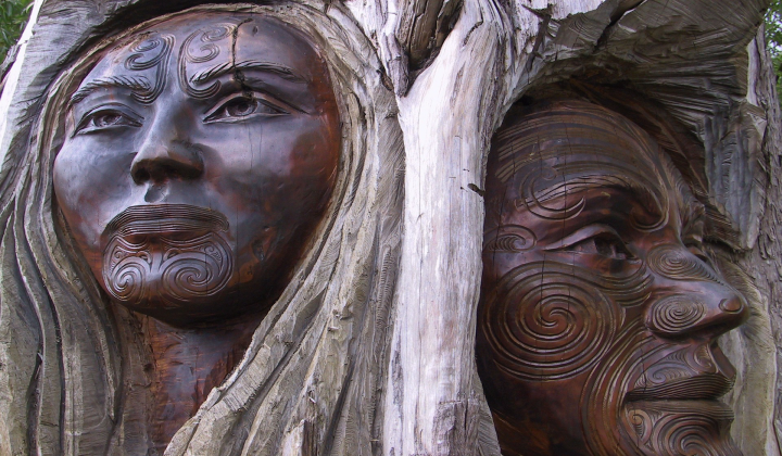 A statue of a woman and a man carved into a tree trunk.