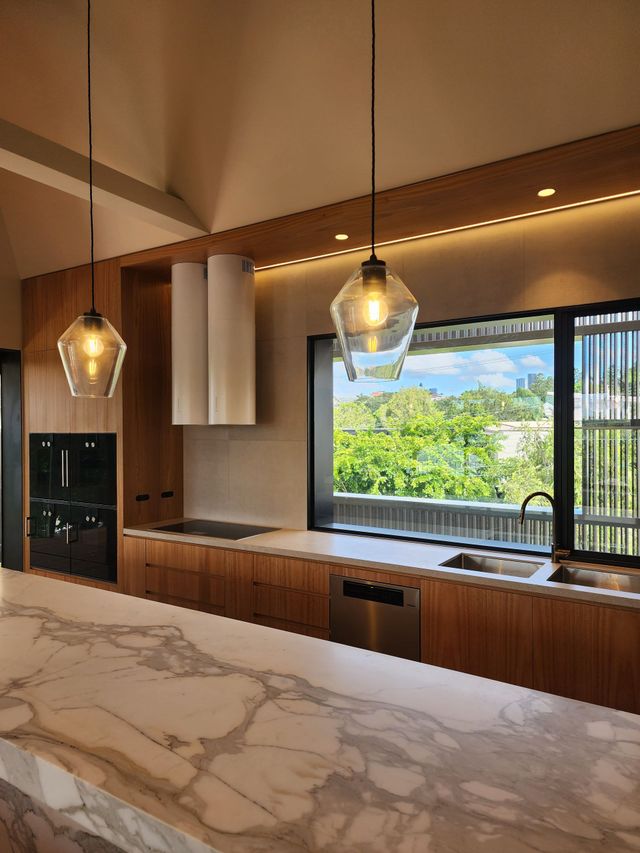 A kitchen with marble counter tops and a large window