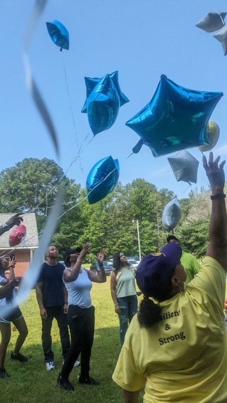 multi generation family having reunion releasing star balloons into the sky