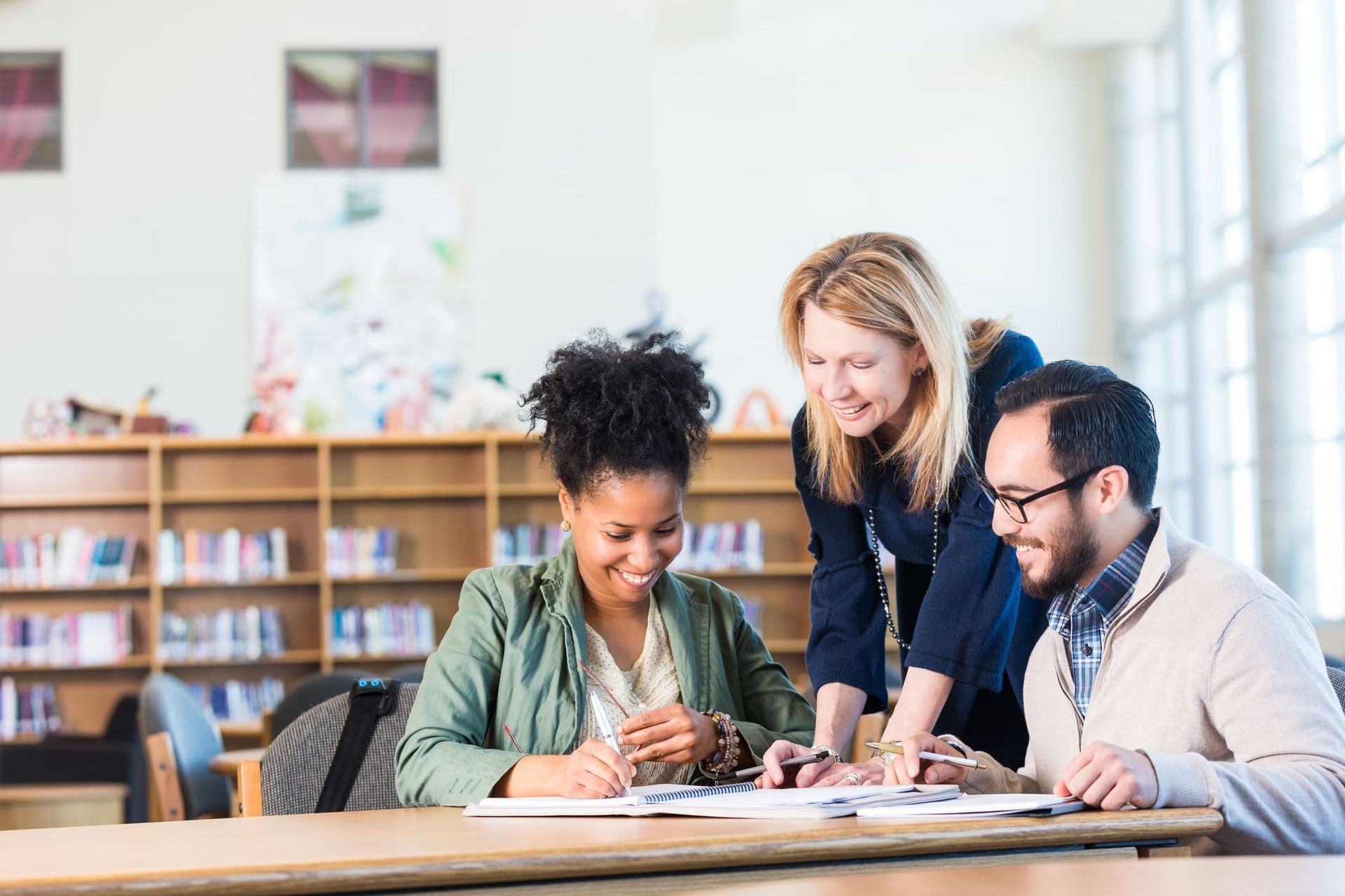 A group of people are sitting at a table in a library.