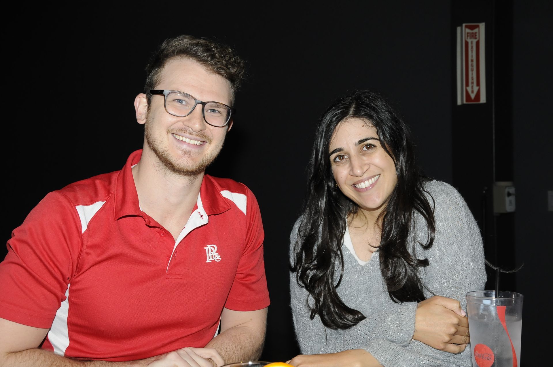 A man and a woman are sitting at a table and smiling for the camera.