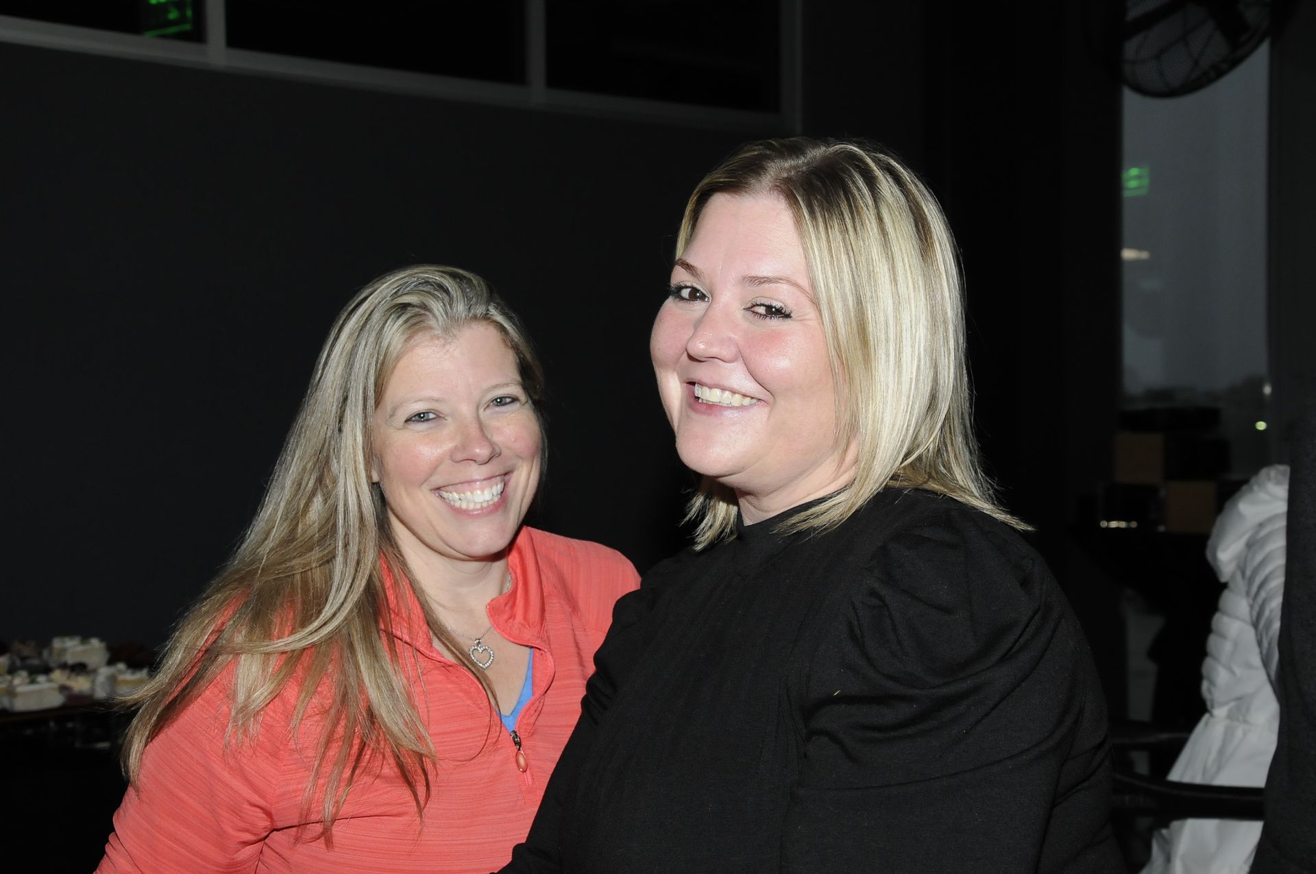 Two women are posing for a picture and smiling for the camera