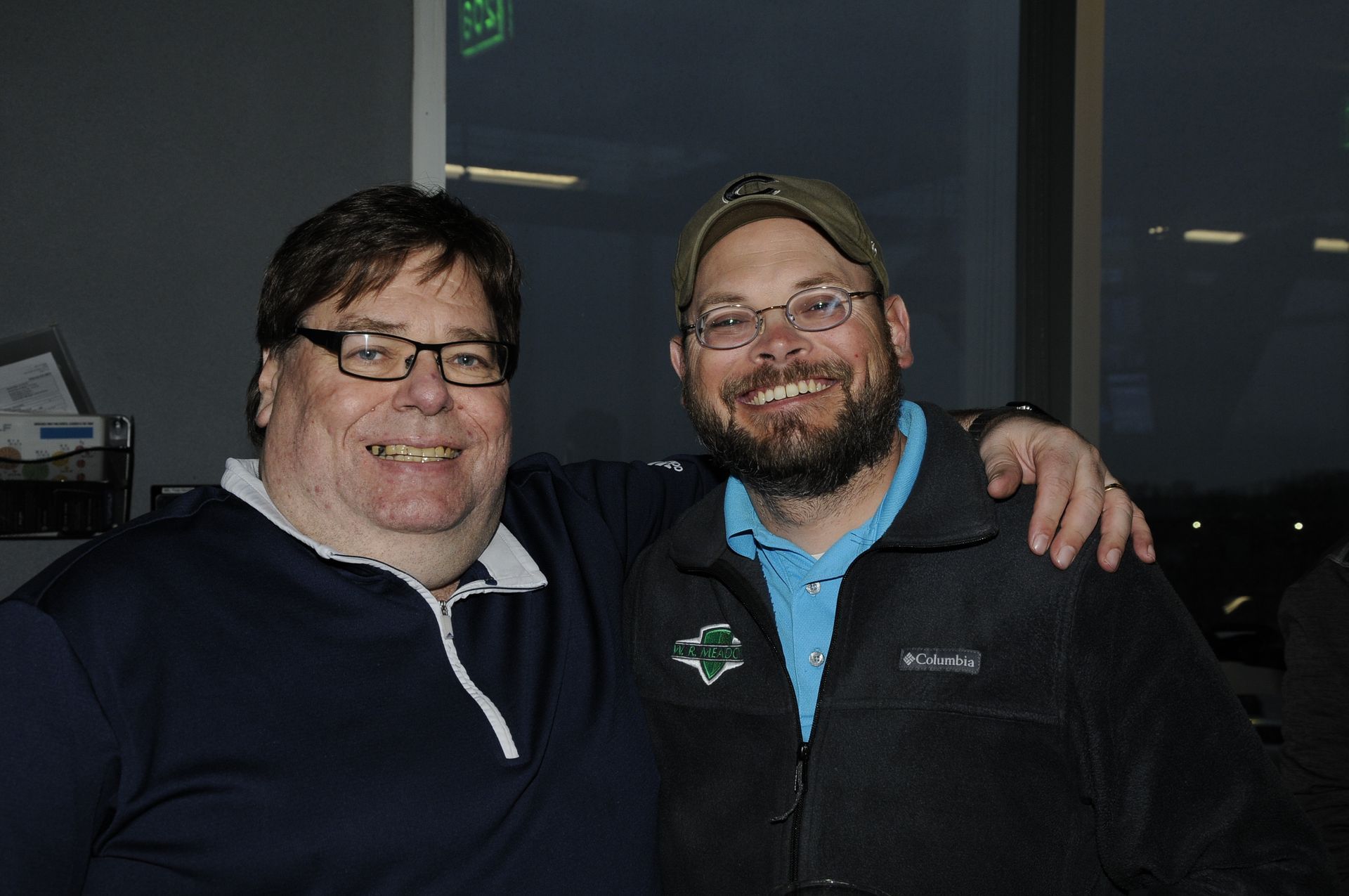 Two men are posing for a picture together and smiling for the camera.