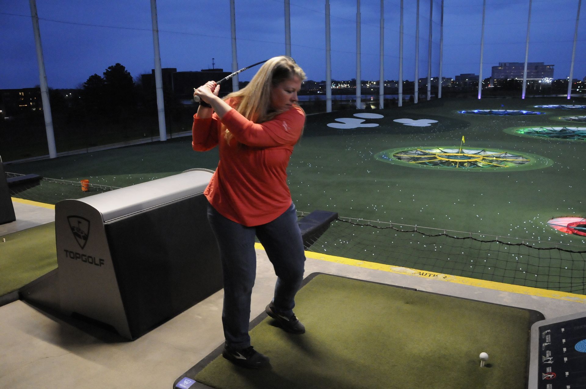 A woman is swinging a golf club on a golf course