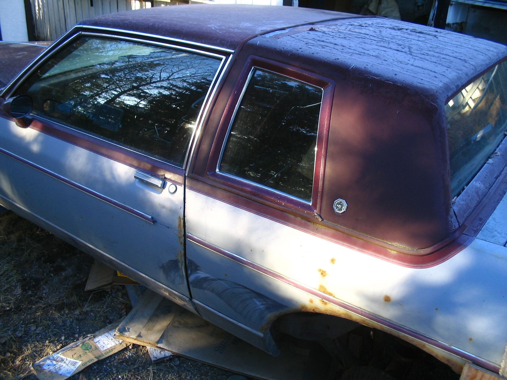 An old car with a purple top is sitting on the ground