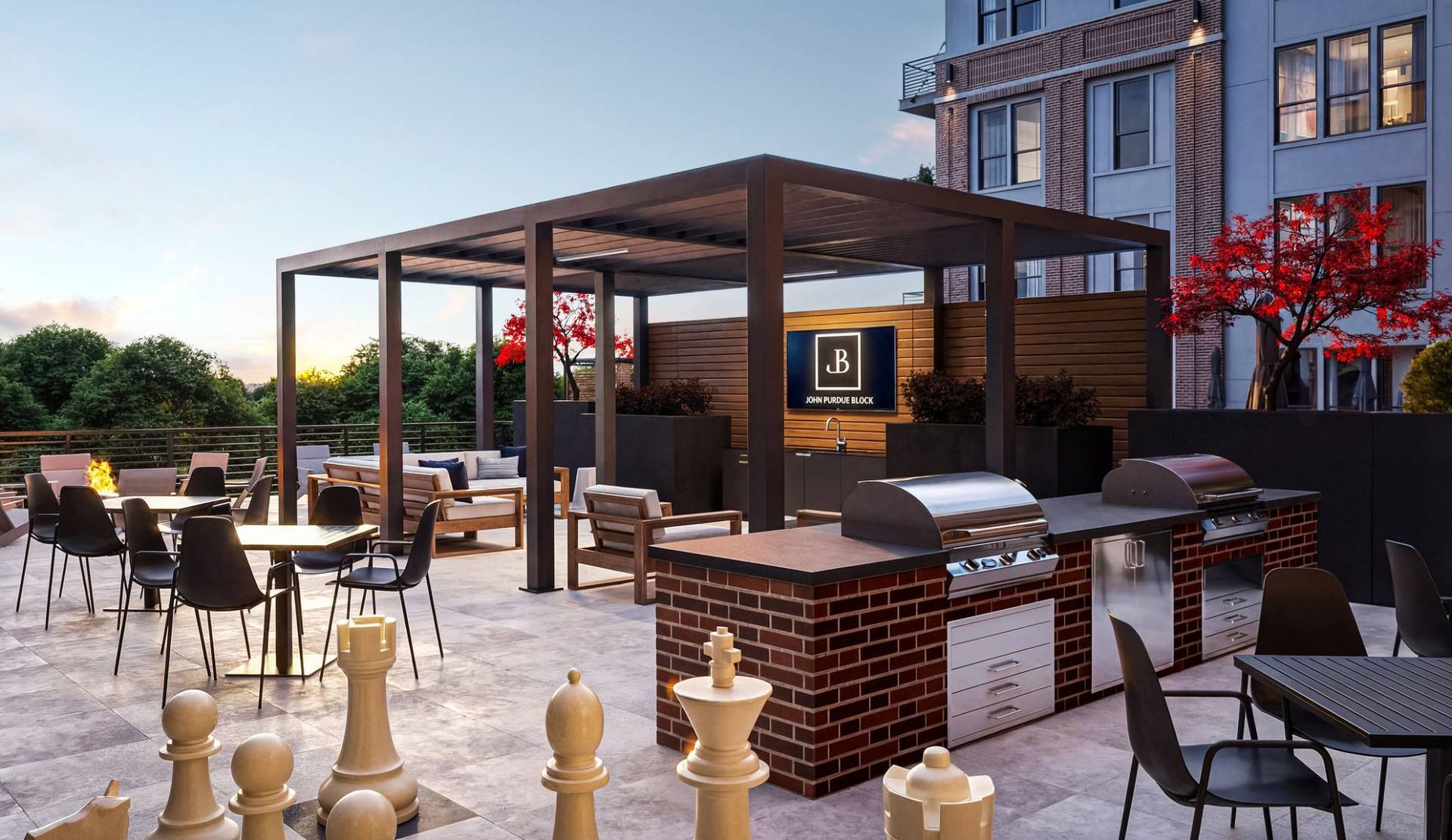 Rooftop outdoor amenity with a pergola, seating, and built-in grills at a modern apartment community.