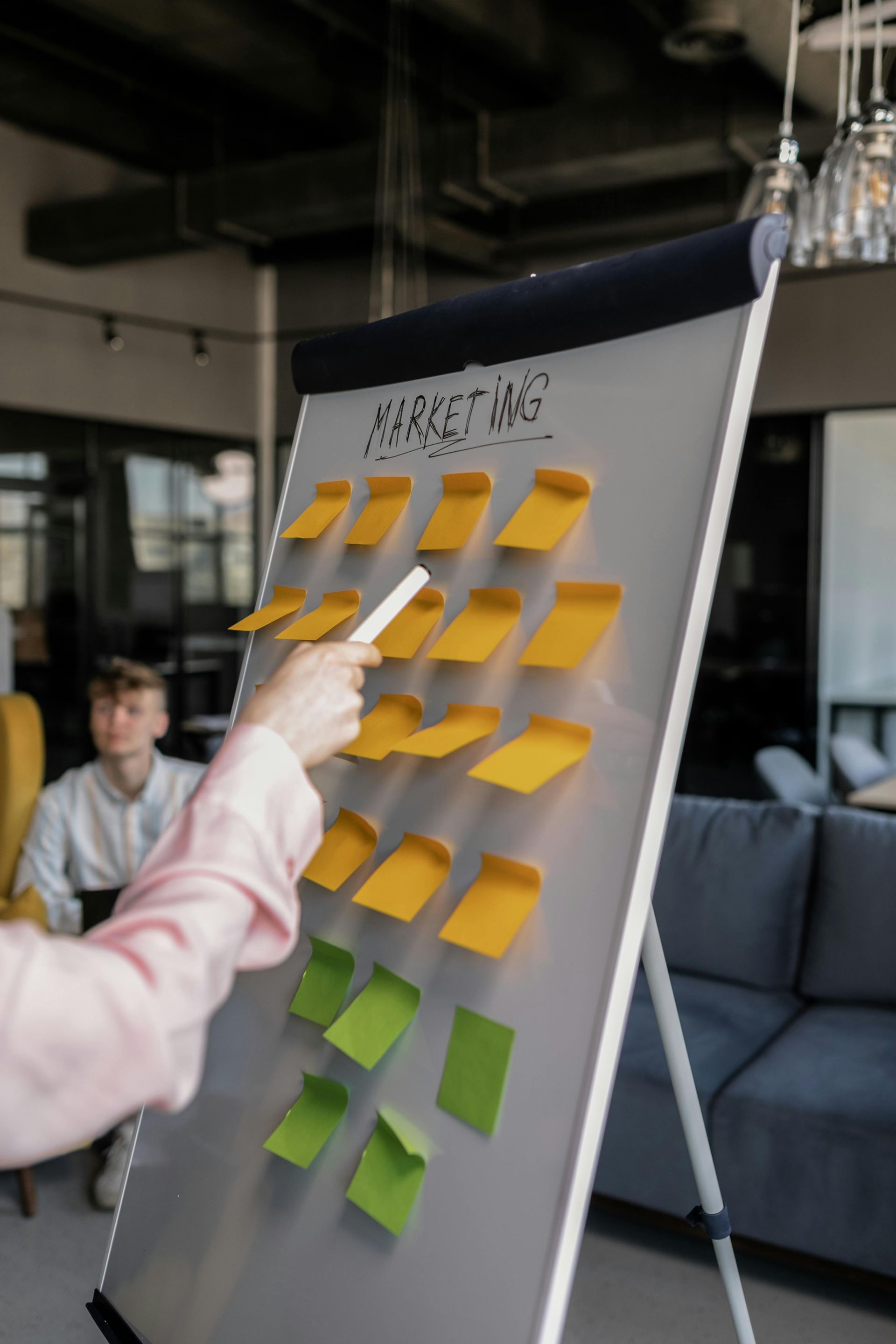 A person is pointing at sticky notes on a whiteboard.