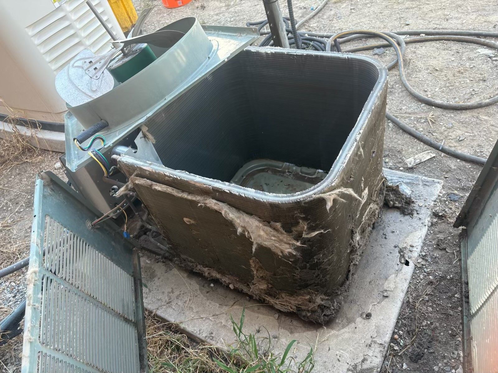 Woman in a white shirt talking on a phone, looking down with a slight smile indoors.