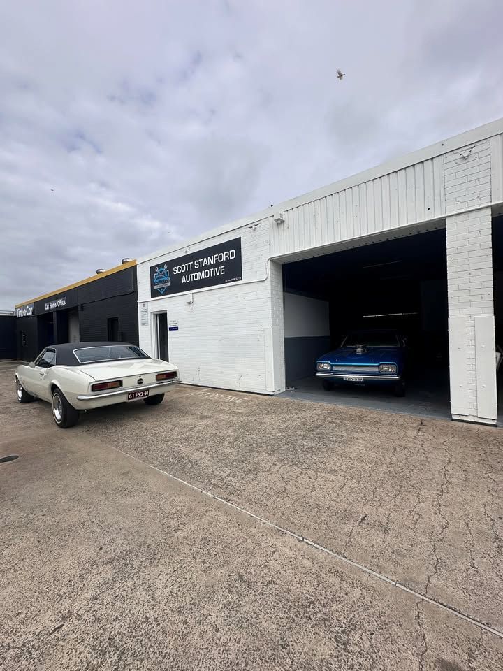 White Classic Car Outside Scott Crawford Automotive With a Blue Car Inside — Scott Stanford Automotive in Nowra, NSW