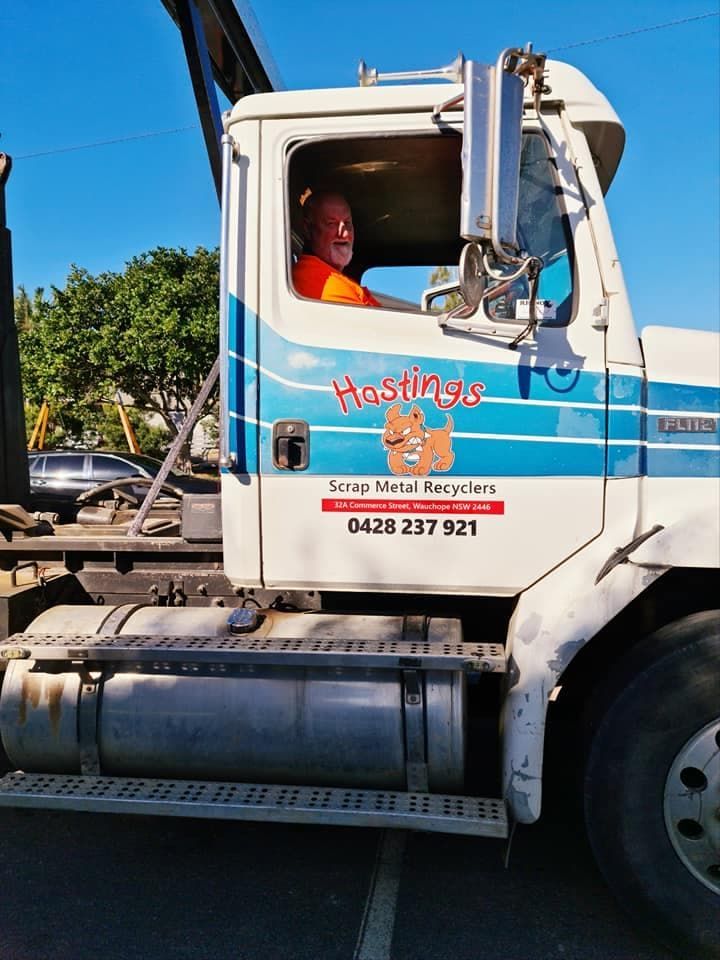 A Man is Driving a Truck That Says Hostings — Hastings Scrap Metal Recyclers in Rollands Plains, NSW