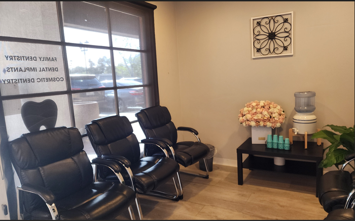 A waiting room with black chairs and a table