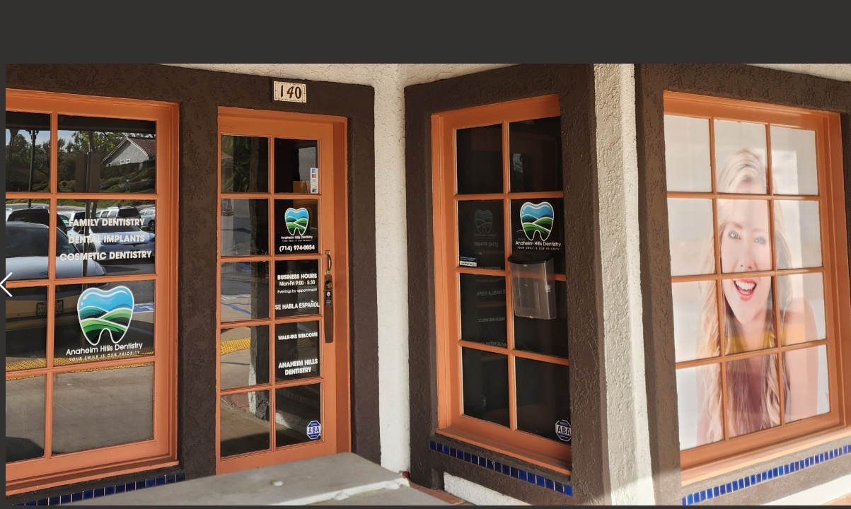 A dental office with a picture of a woman on the window.