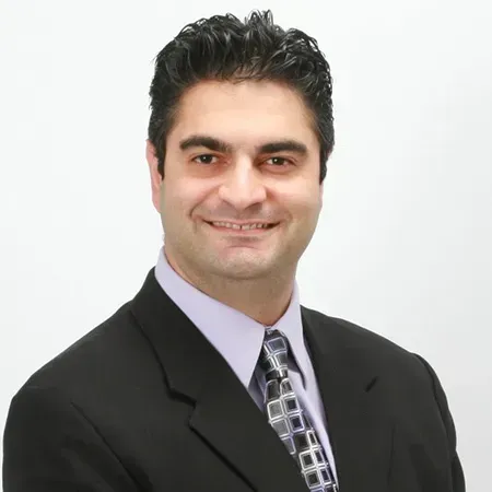 A man in a suit and tie is smiling for the camera