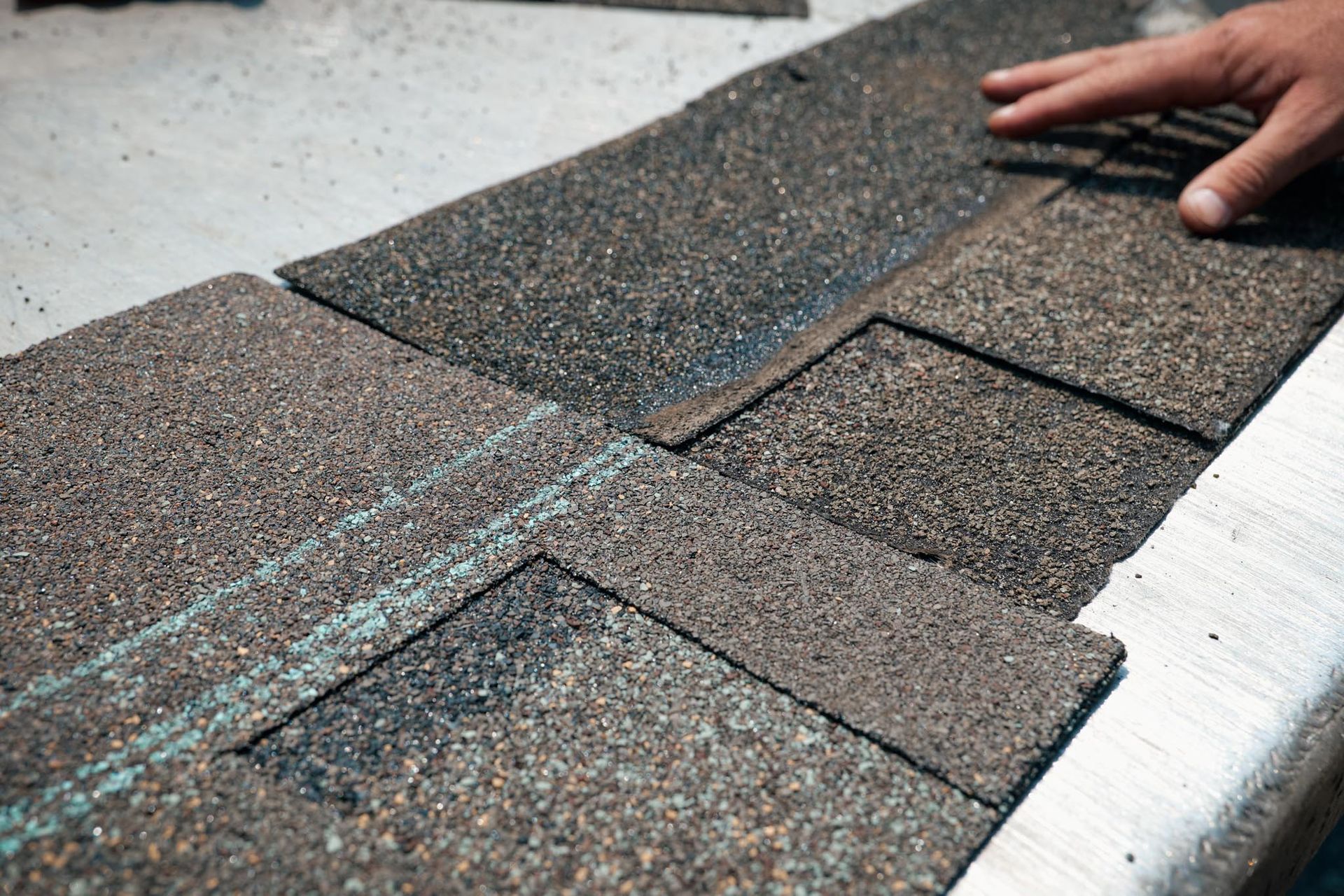 A person is laying shingles on a roof.
