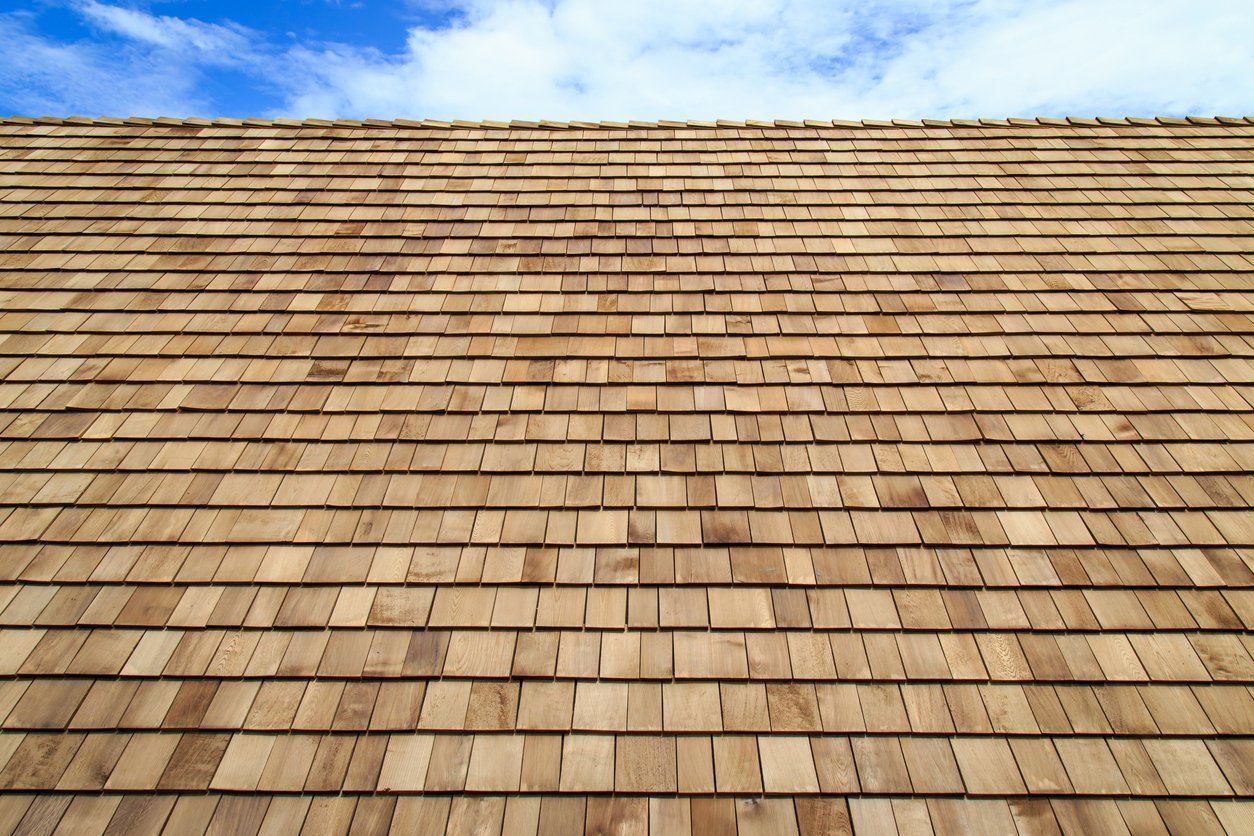 Looking up at a wooden roof with a blue sky in the background
