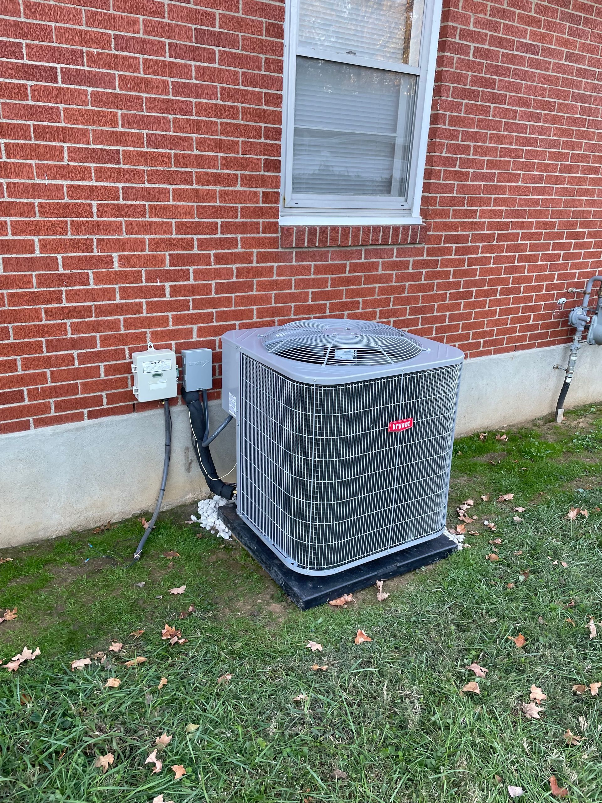 Air conditioning unit outside a brick building.