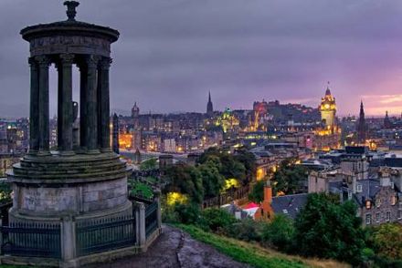 Edinburgh skyline at dusk viewed from Calton Hill with the Dugald Stewart Monument in the foreground