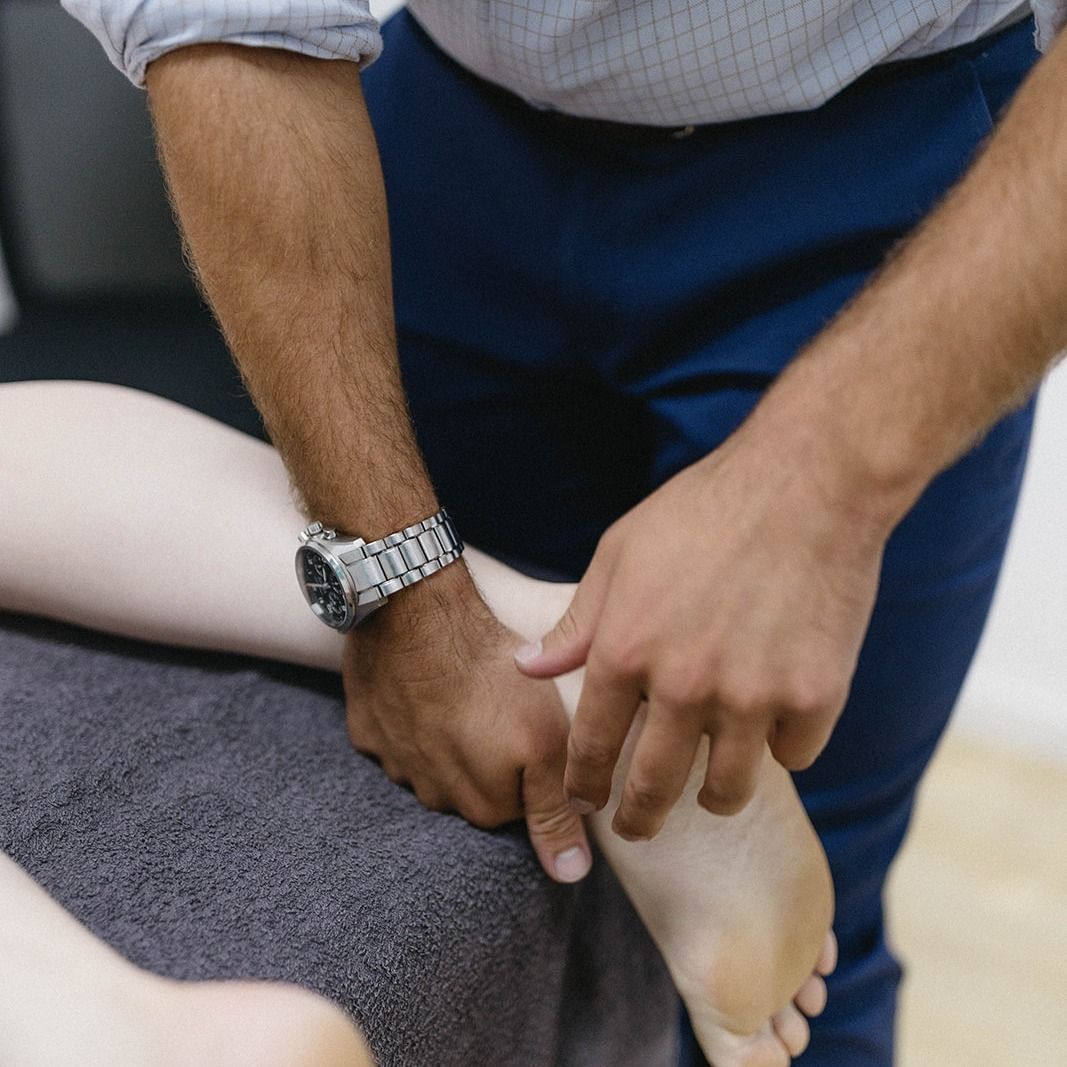 Person Holding a Lower Leg and Ankle During a Massage or Therapy Session — Lord Street Podiatry in Port Macquarie, NSW
