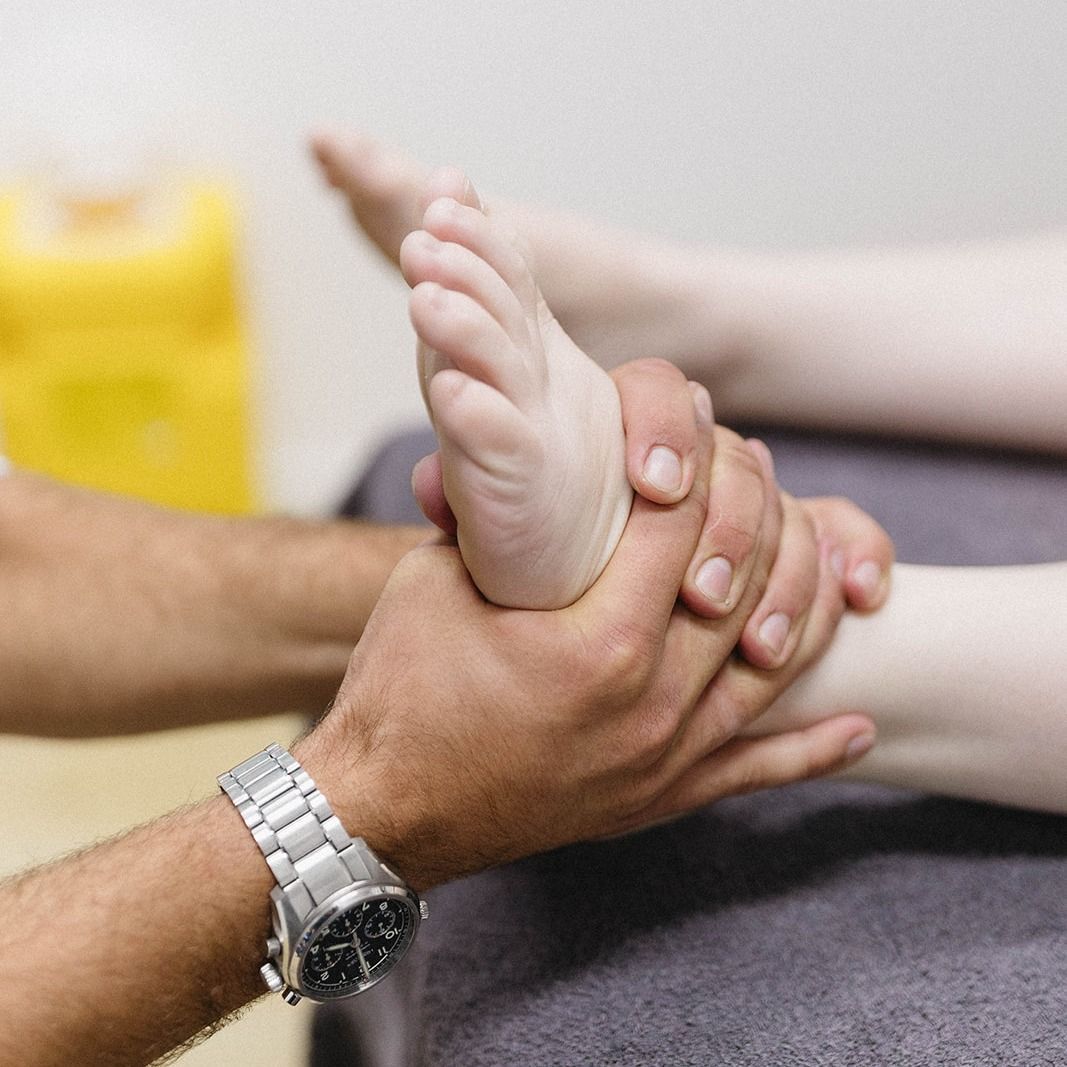 Hands Holding and Gently Massaging a Raised Foot During a Foot Therapy Session — Lord Street Podiatry in Port Macquarie, NSW
