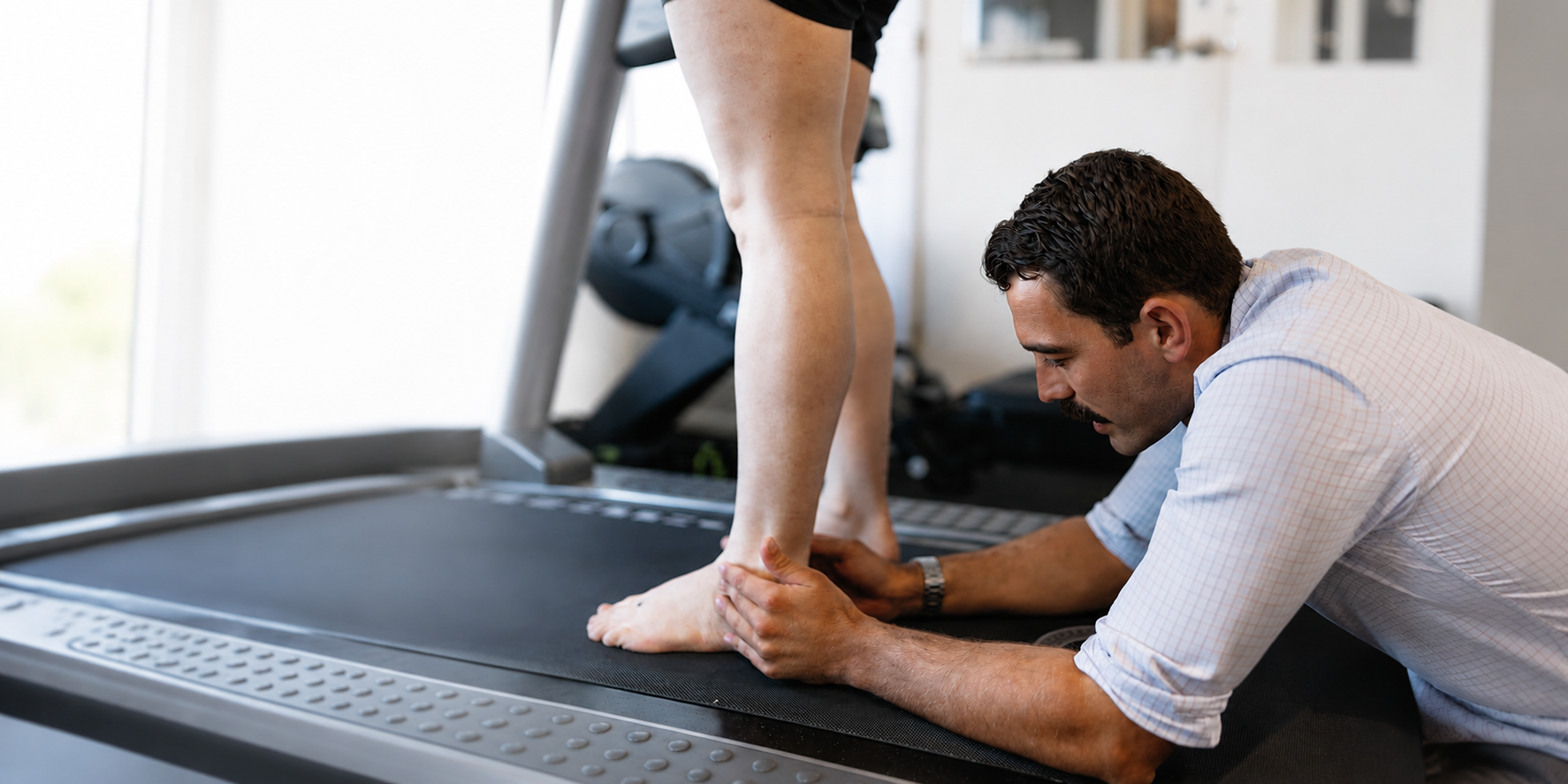Physical Therapist Stretching a Client’s Foot on a Treadmill in a Gym — Lord Street Podiatry in Port Macquarie, NSW