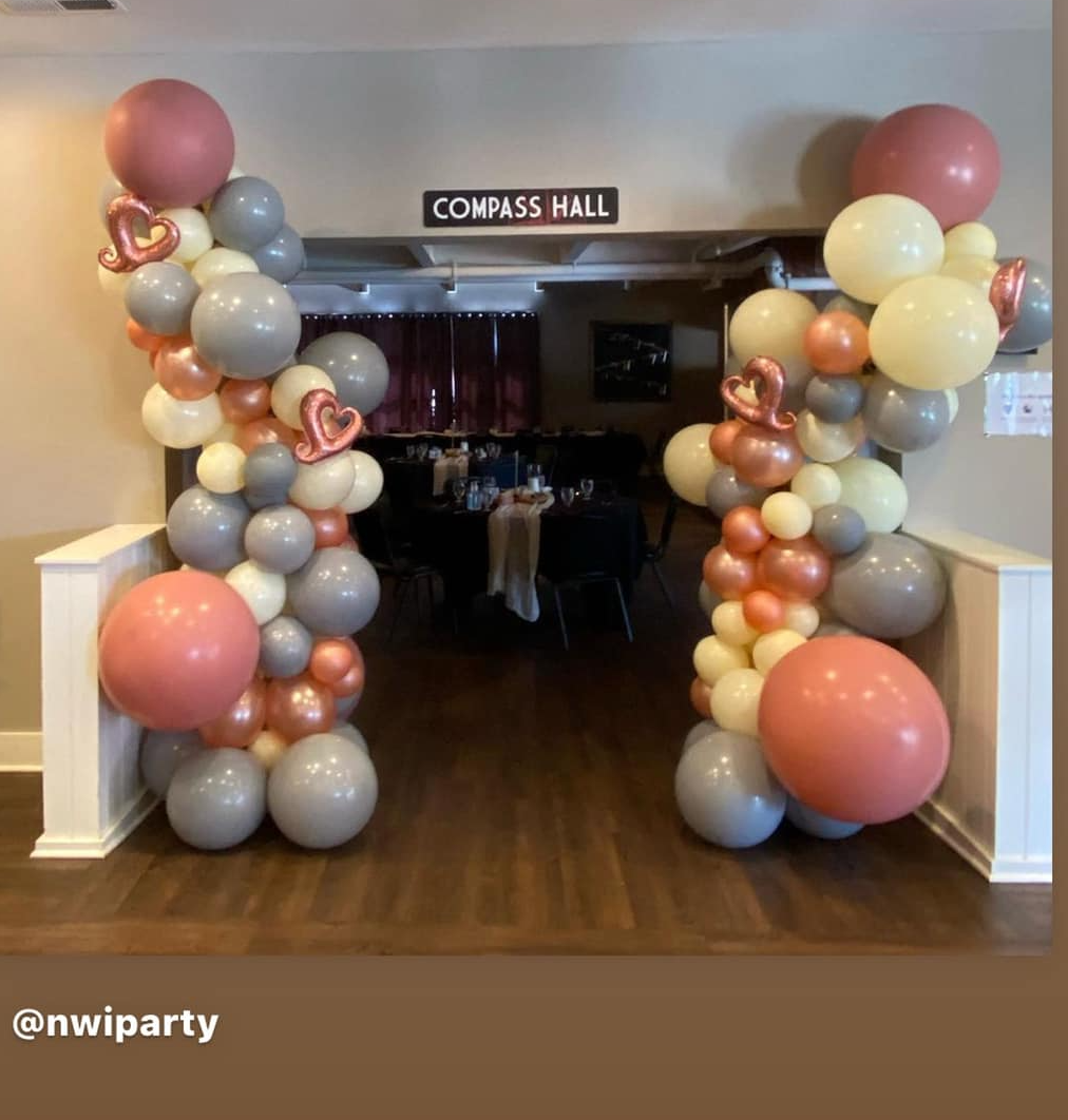 Elegant wedding shower grand entrance in the Chicago suburbs, featuring a 12' organic balloon column in grey, pink, and off-white with heart accents.